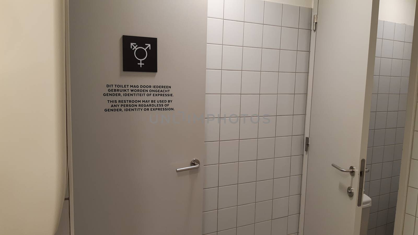 Antwerp, Belgium, May 2020: Gender neutral toilet symbol and sign on a door, in Dutch and English language