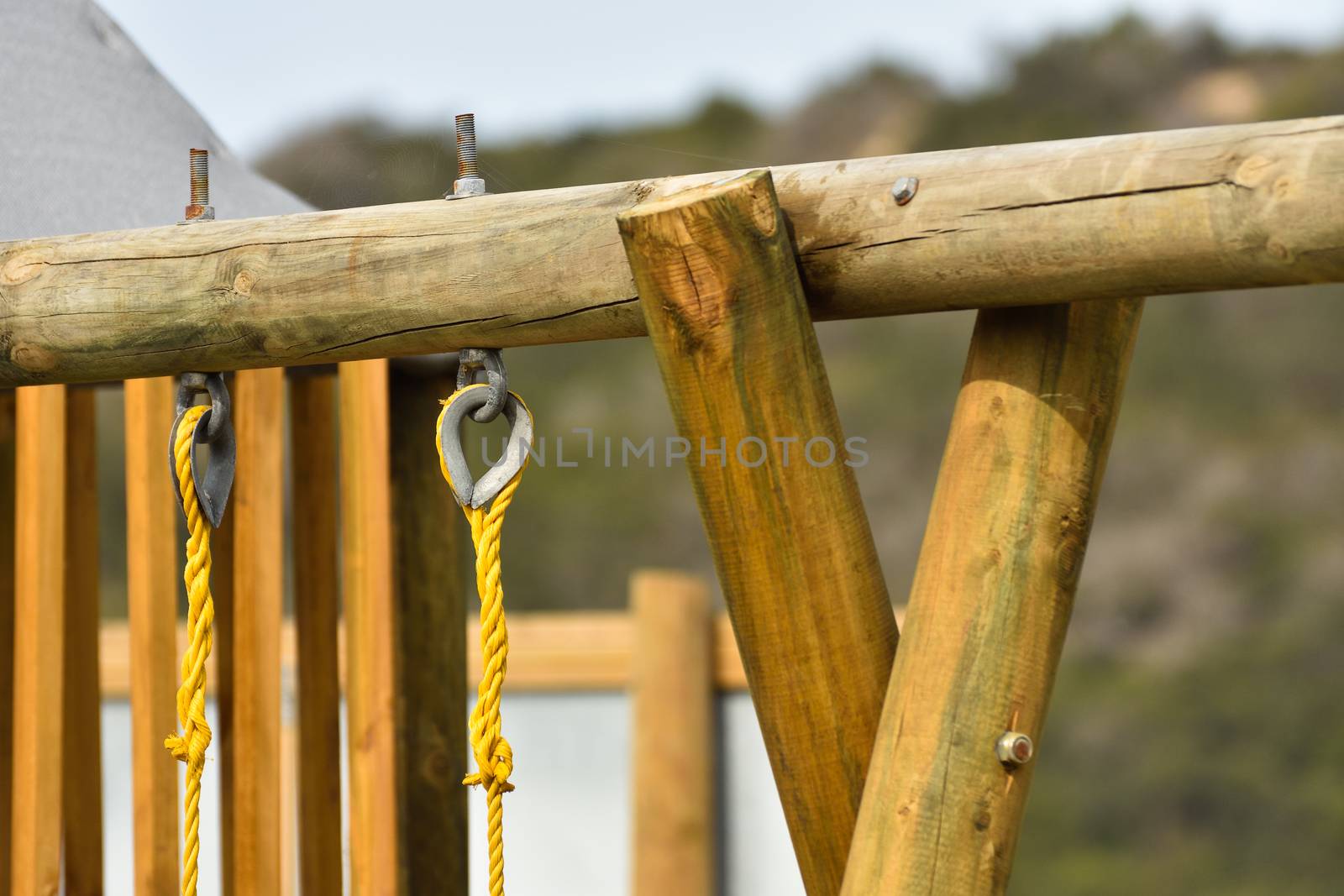 Wooden log frame structure with yellow swing ropes in playground, Mossel Bay, South Africa