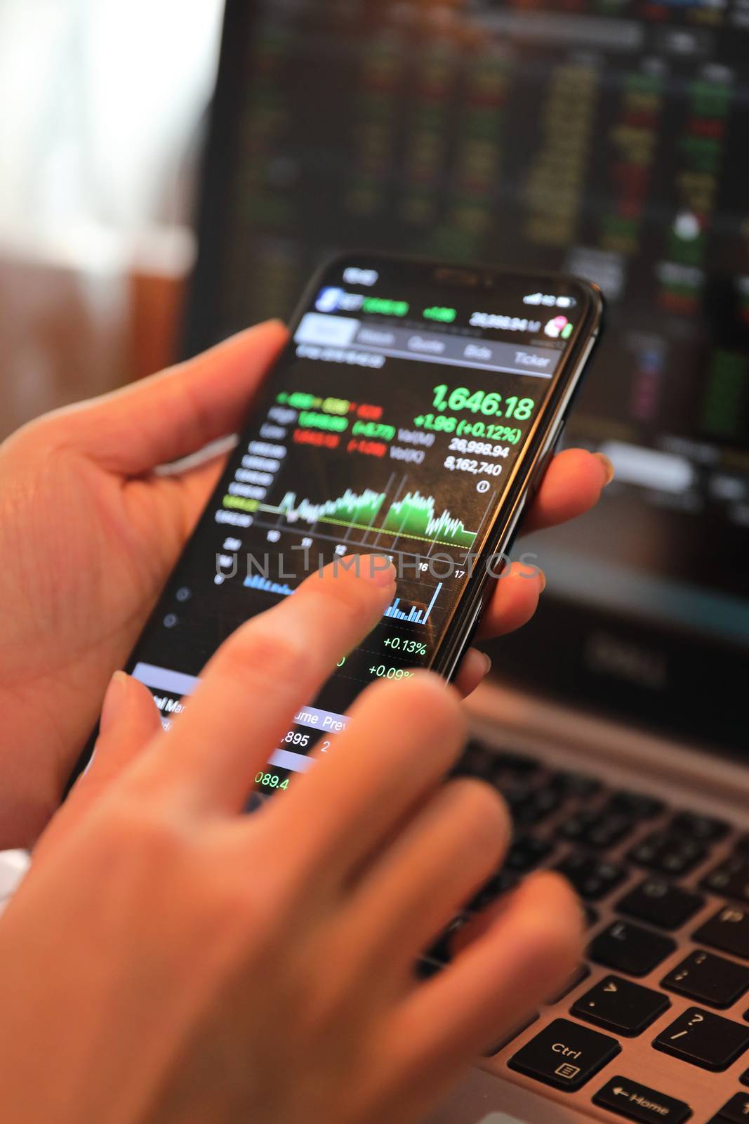 Female hand with smartphone trading stock online in coffee shop , Business concept