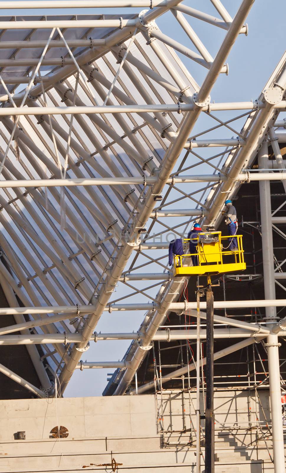 workers in air build grand stands construcion of new stadium