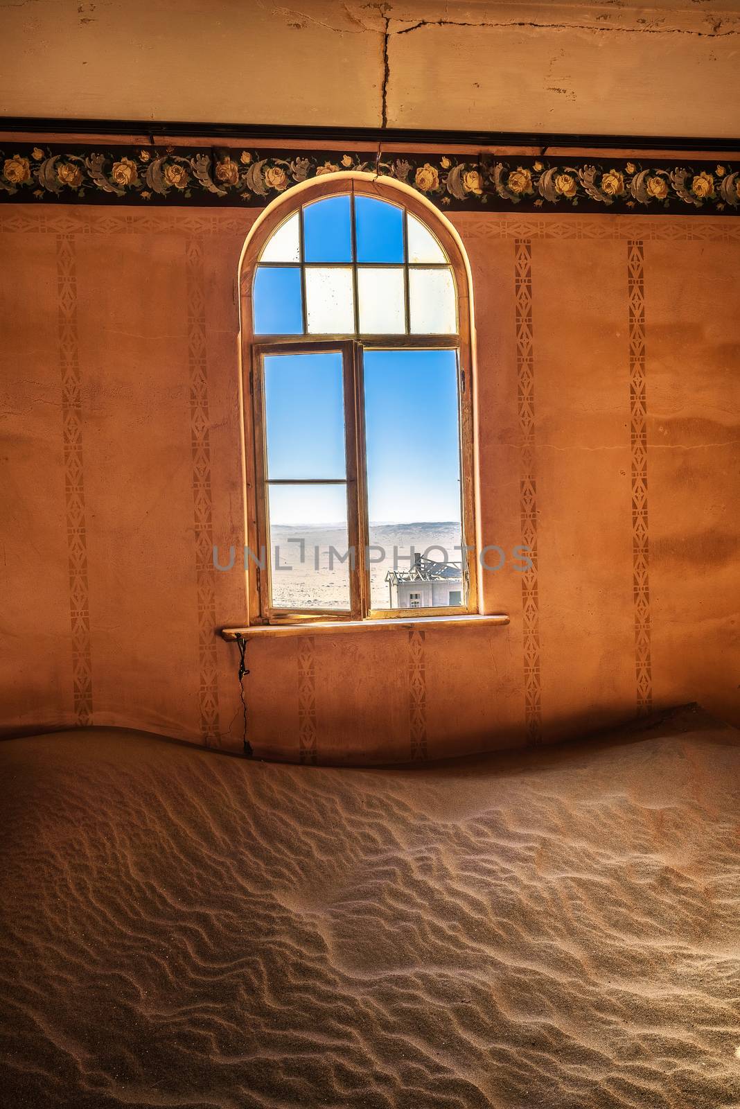 Empty room with a window and desert sand located in the ruins of the ghost town Kolmanskop in the Namib desert near Luderitz, Namibia, Southern Africa