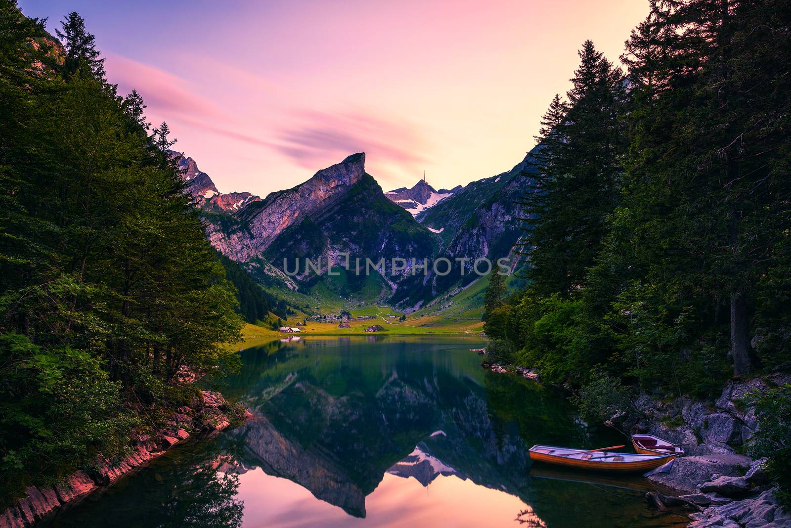 Sunset over the Seealpsee lake with small boats in the Swiss Alps, Switzerland by nickfox