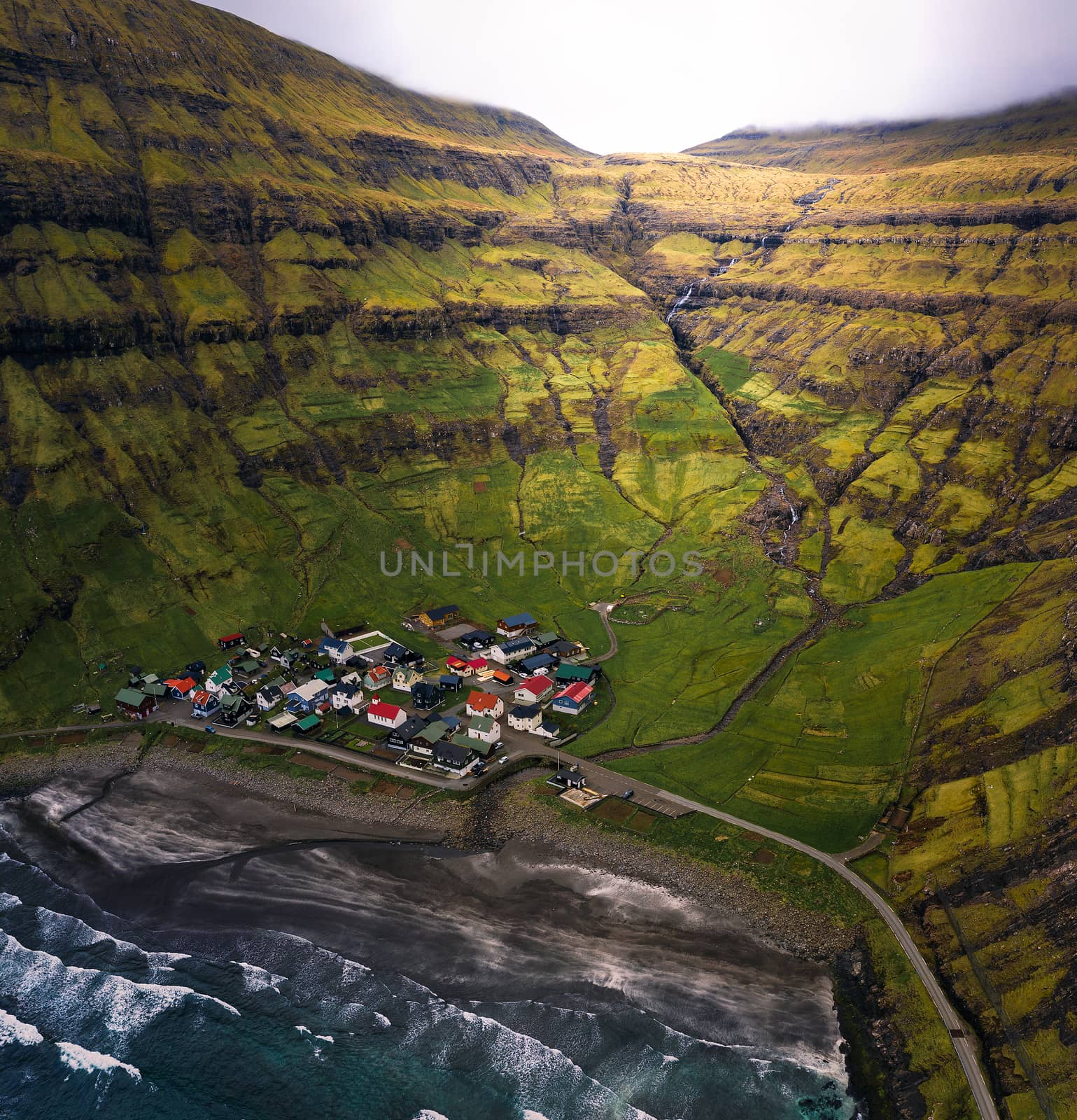 Aerial view of the Tjornuvik village and its beach located at a beautiful bay in the Faroe Islands, Denmark.
