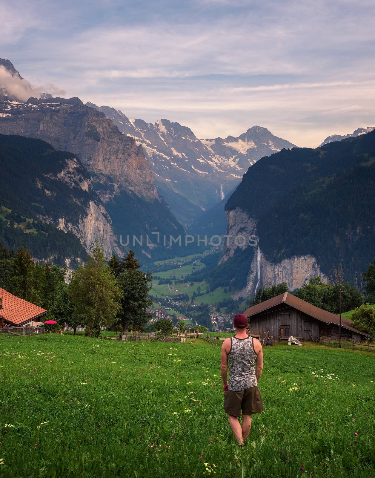 Tourist looks at the Lauterbrunnen valley from the alpine village of Wengen located in the Swiss Alps near Interlaken in the Bernese Oberland of Switzerland.