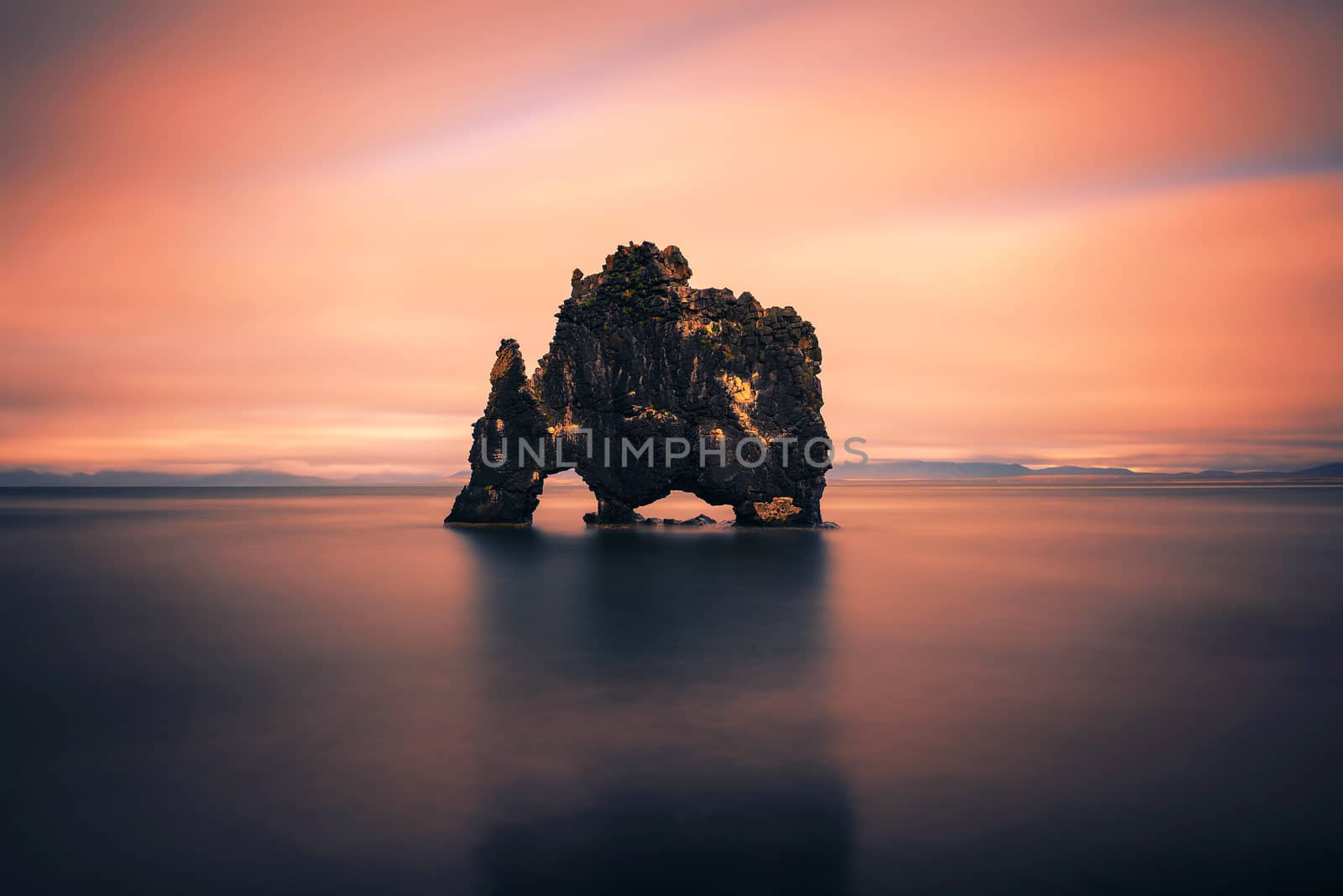 Sunset at the Hvitserkur basalt stack in northern Iceland. Hvitserkur is a spectacular rock in a shape of a dragon or dinosaur drinking water from the ocean. Long exposure.