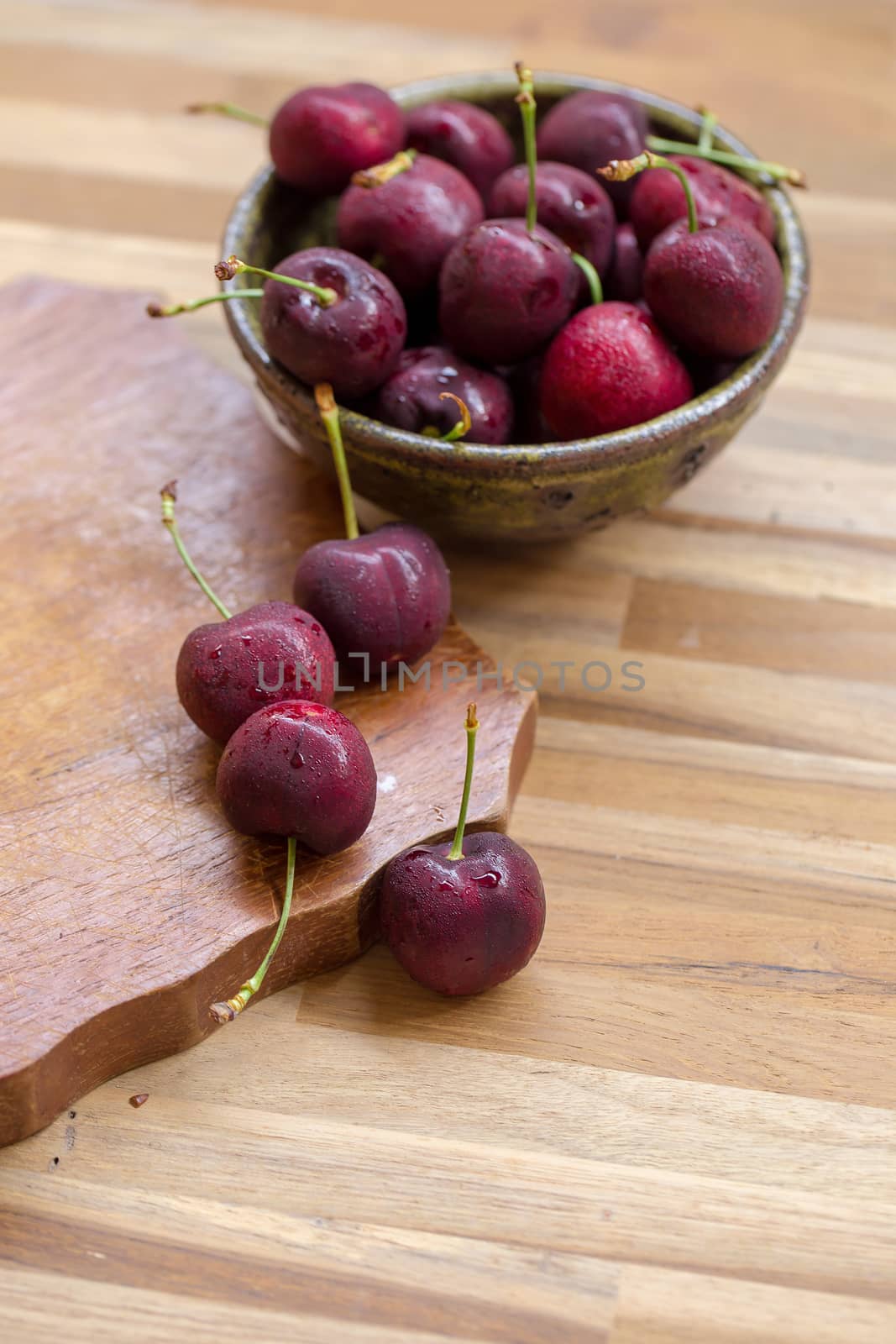 Bowl of Cherries. Red cherries in a bowl on wooden background.