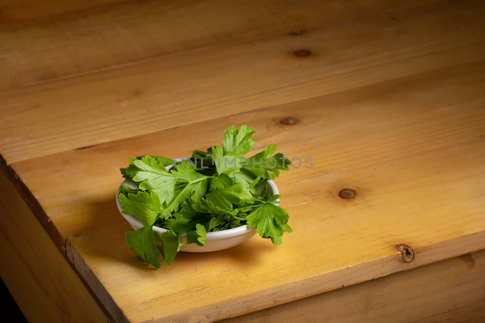Parsley in a bowl on a wooden table