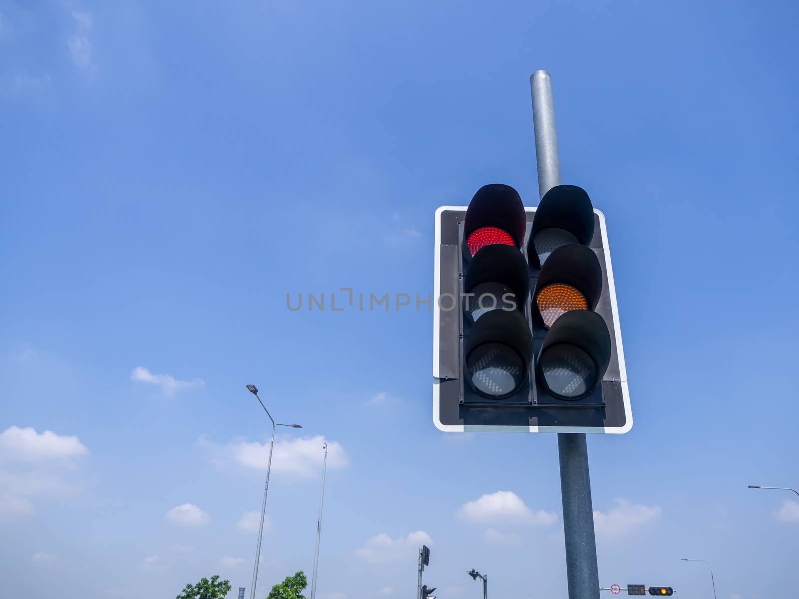 traffic lights against a vibrant blue sky by shutterbird