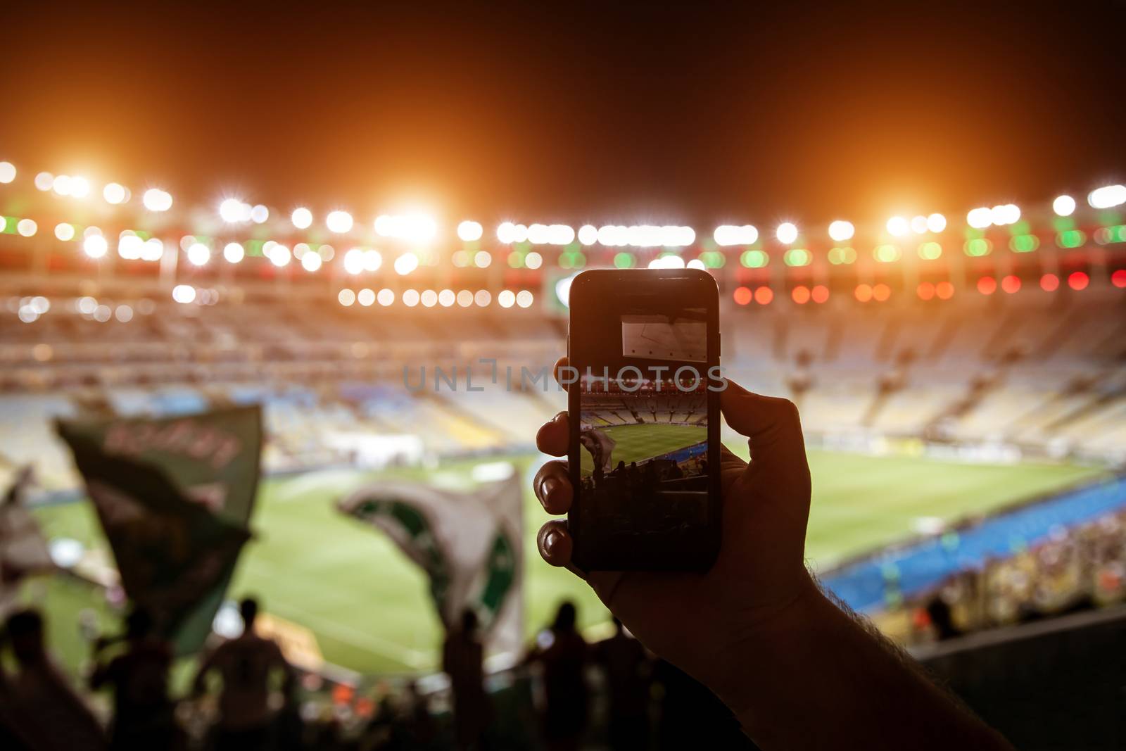 Smartphone photographing football game on the stadium by 9parusnikov