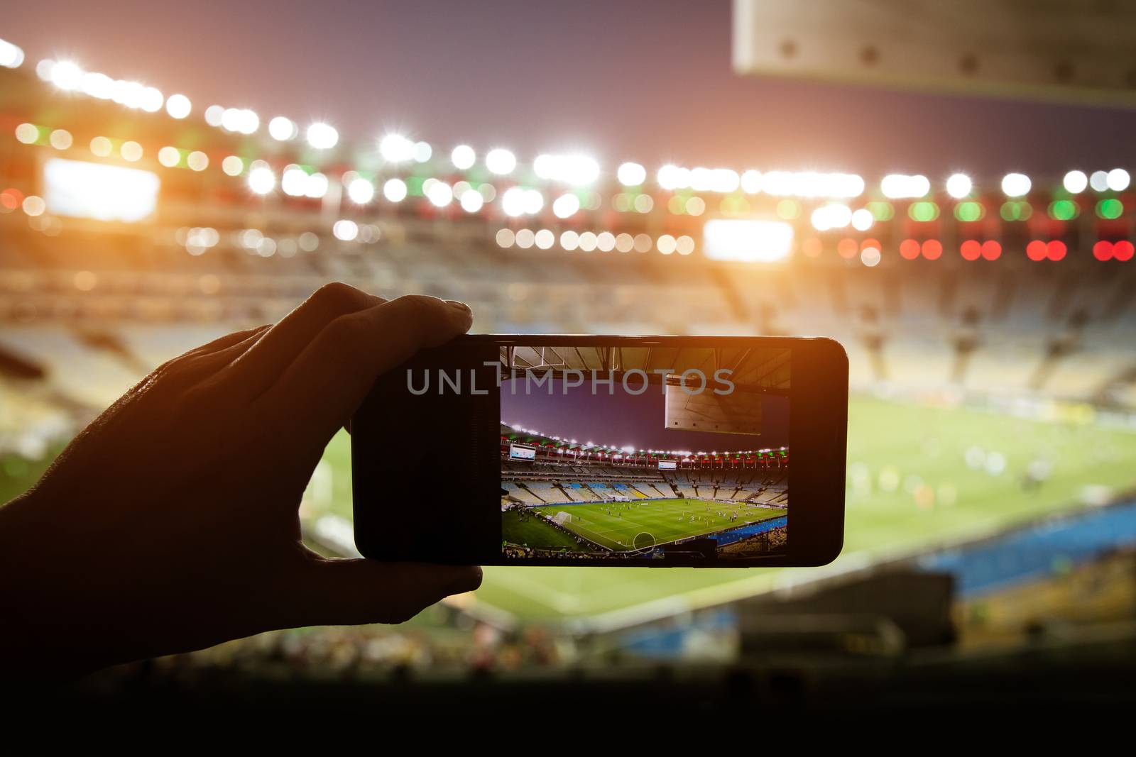 Smartphone photographing football game on the stadium by 9parusnikov