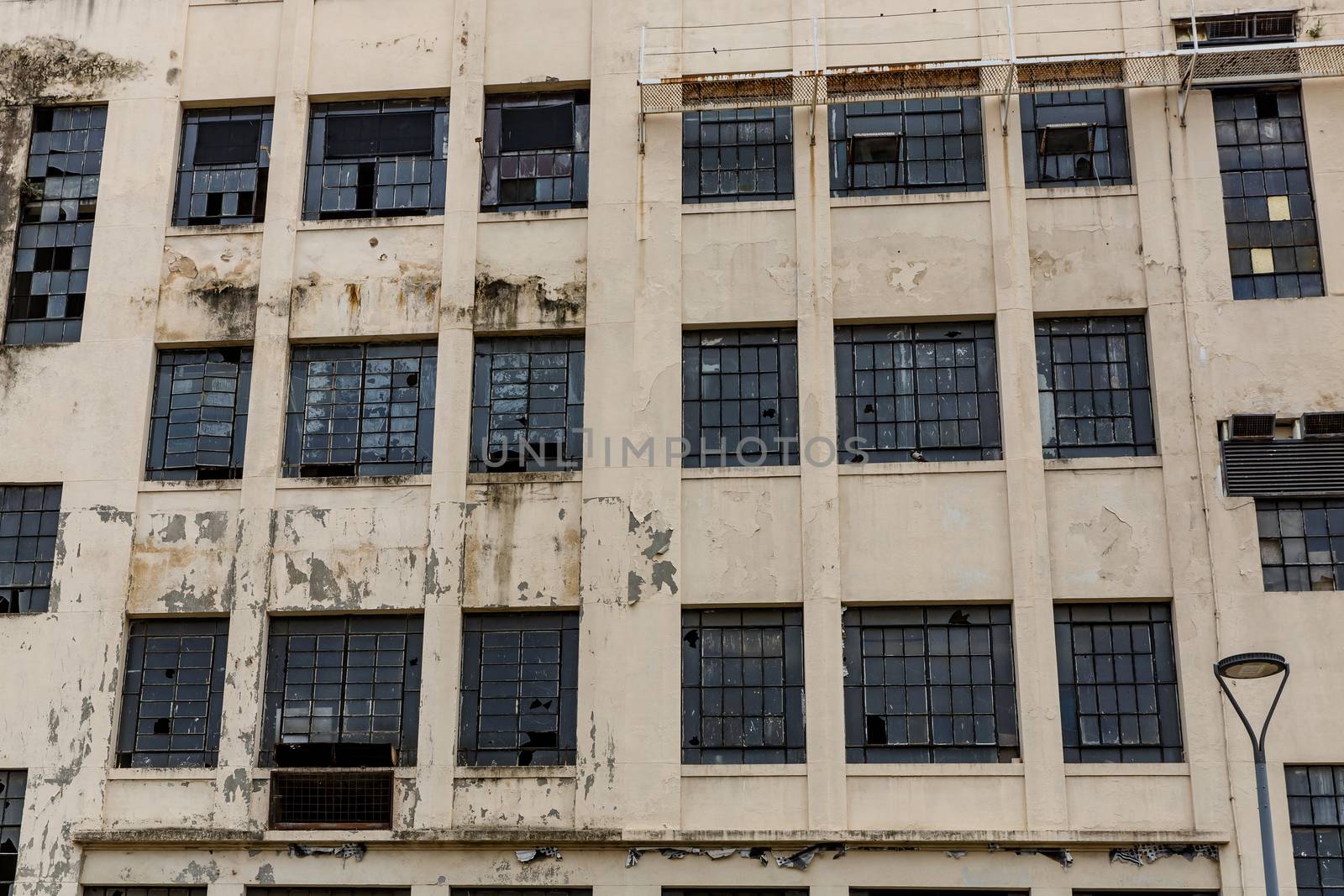 The facade of an abandoned building. Broken windows and peeling paint