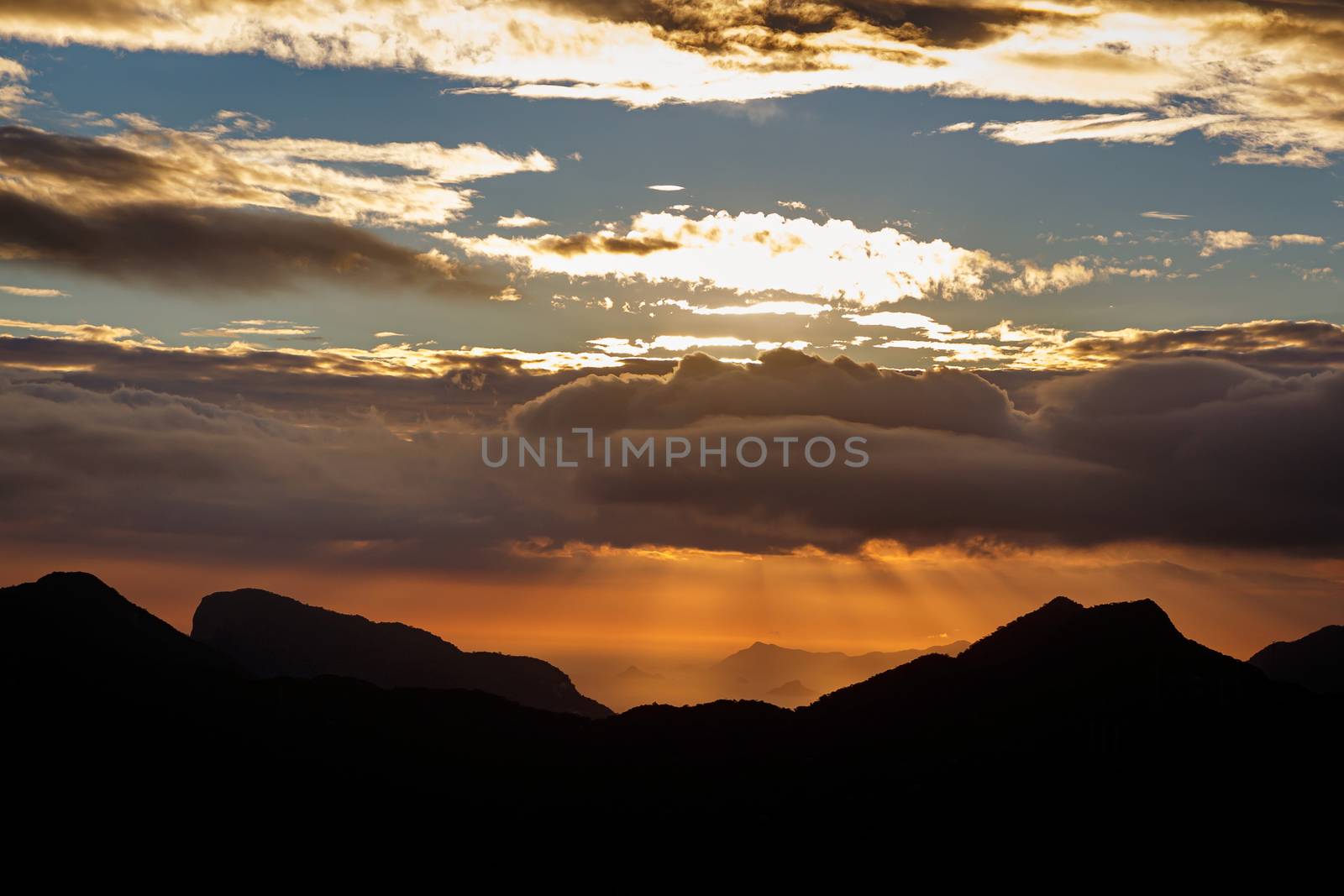 Sunset. The sun above the line of mountains