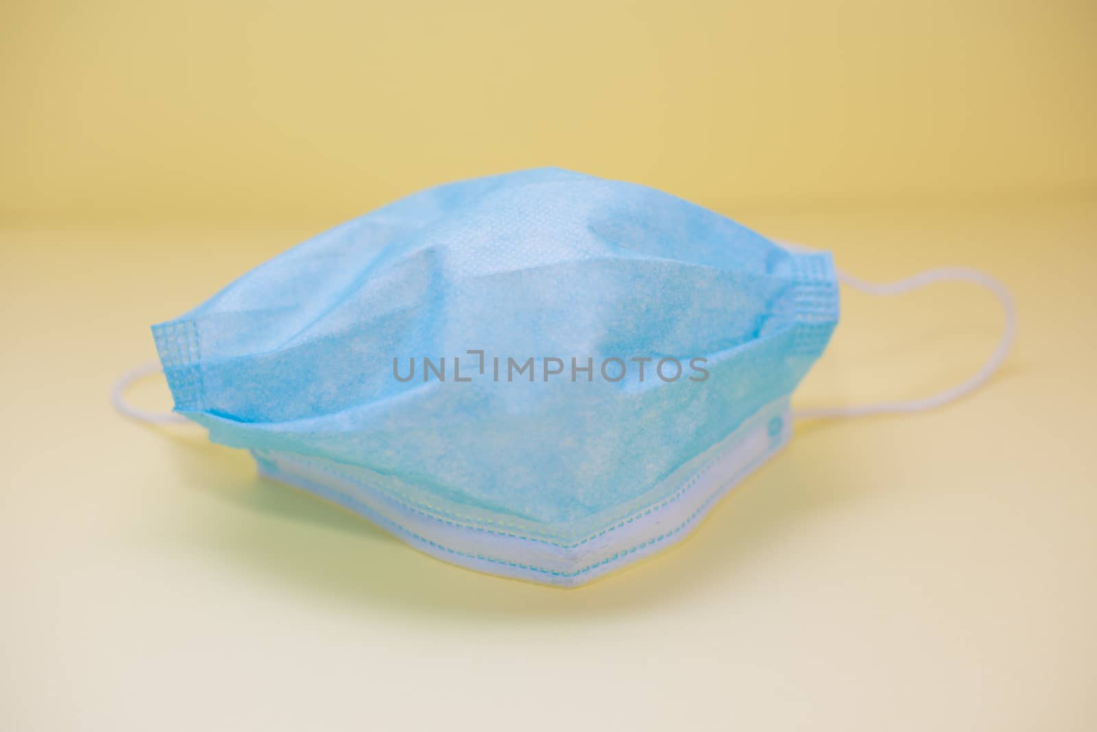 Close up shot of surgical mask isolated against yellow background by rushay