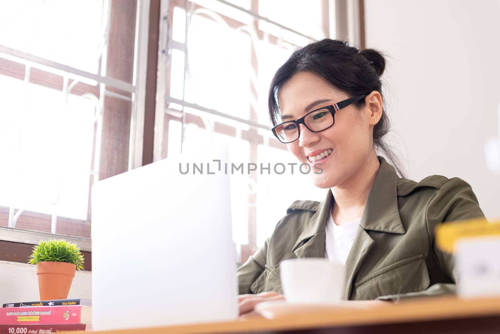 Modern young Asian woman working from home with happy and smile.