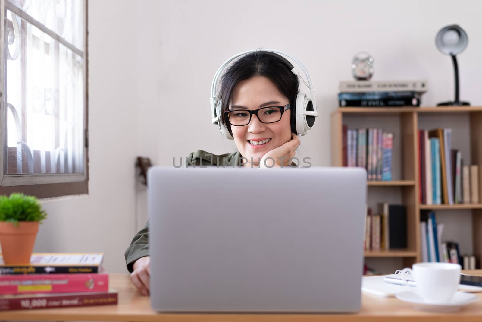 Modern young Asian woman working from home with happy, smile, an by animagesdesign