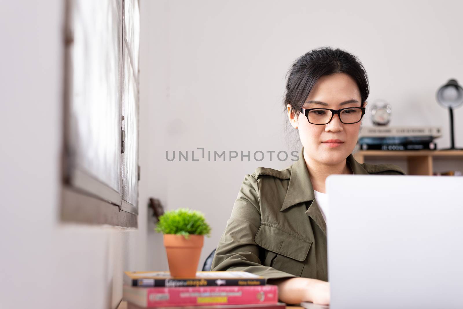 Modern young Asian woman working from home. by animagesdesign