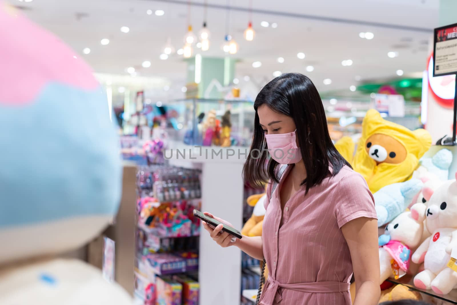 Editorial: Central Bangna Bangkok City, Thailand, 6th Jun 2020. An Asian woman shopping in the toy store after opening lockdown with pink mask and social distancing.