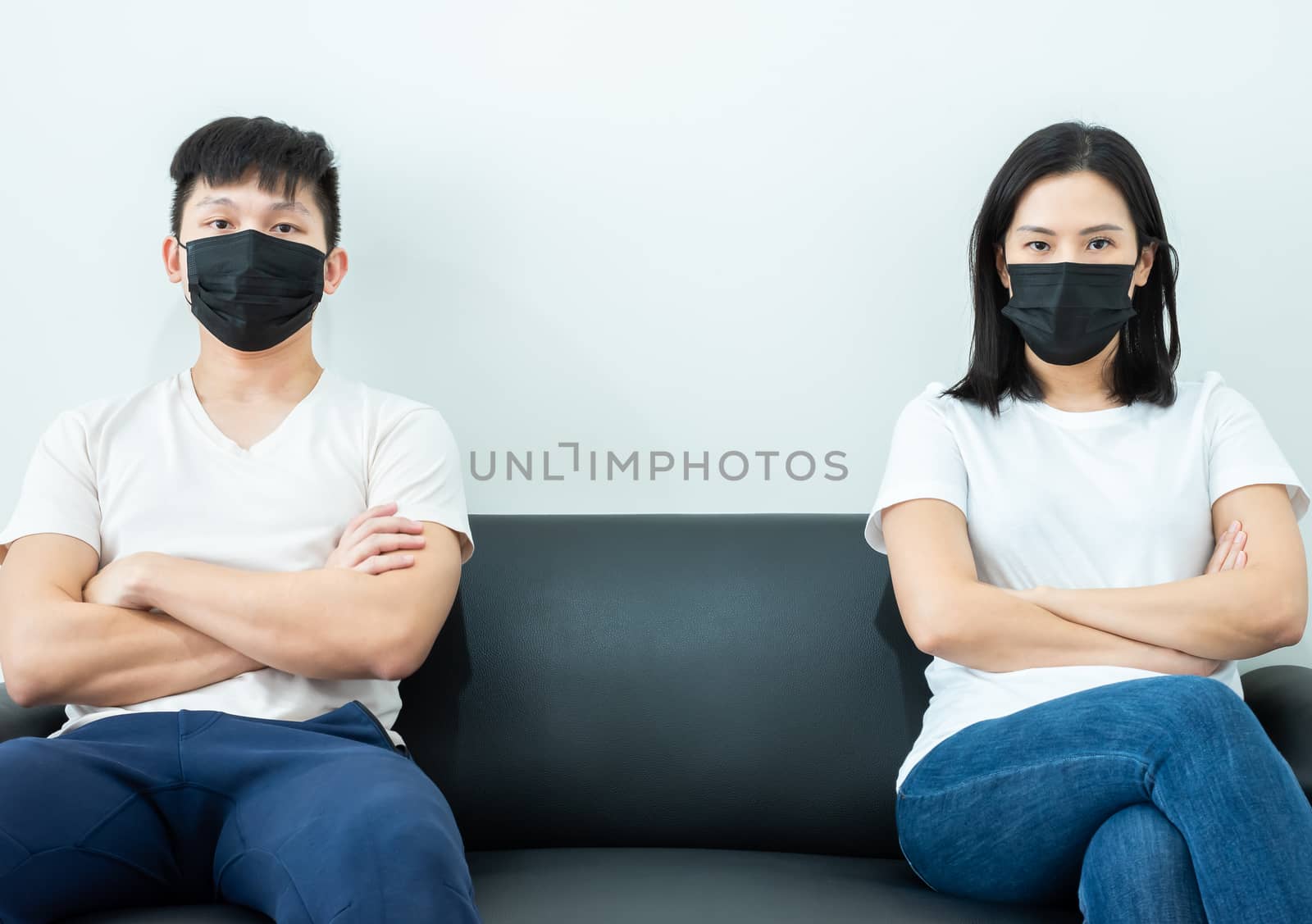 An Asian couple wearing a black mask and stays together with boring and social distancing.