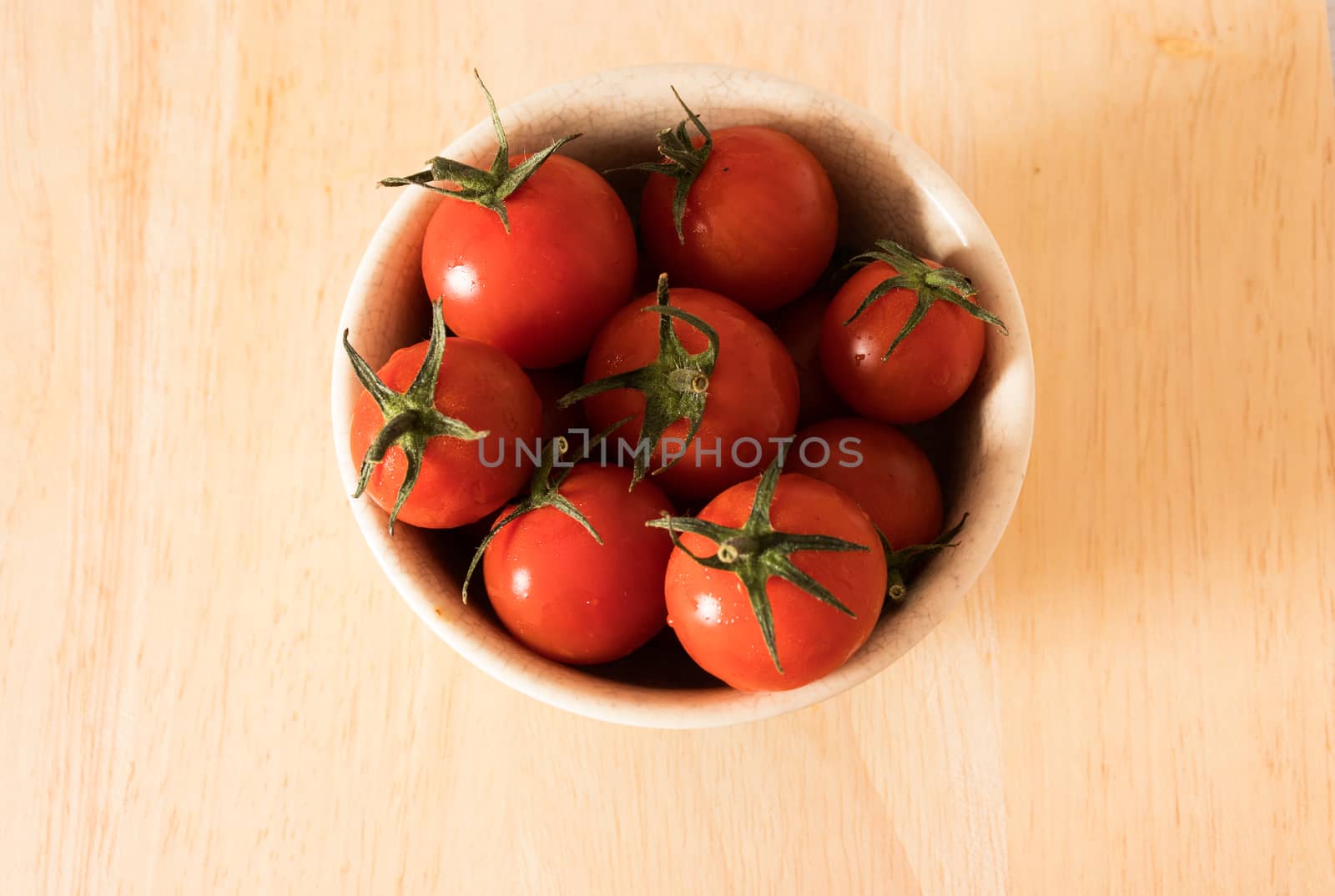 Red tomato on a cutting board wiht wooden background.