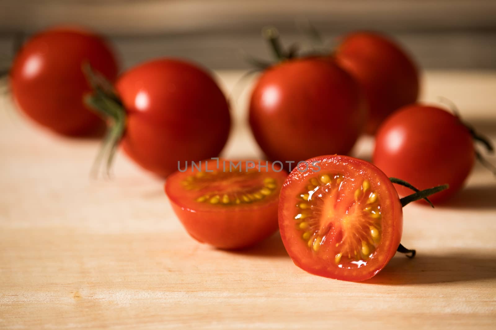 half tomato on cutting board by Khankeawsanan