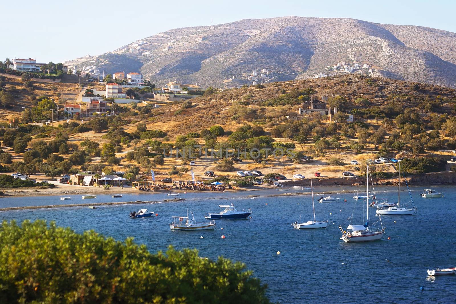 Scenic view of sea bay with boats and beach in background, Anavyssos, Greece