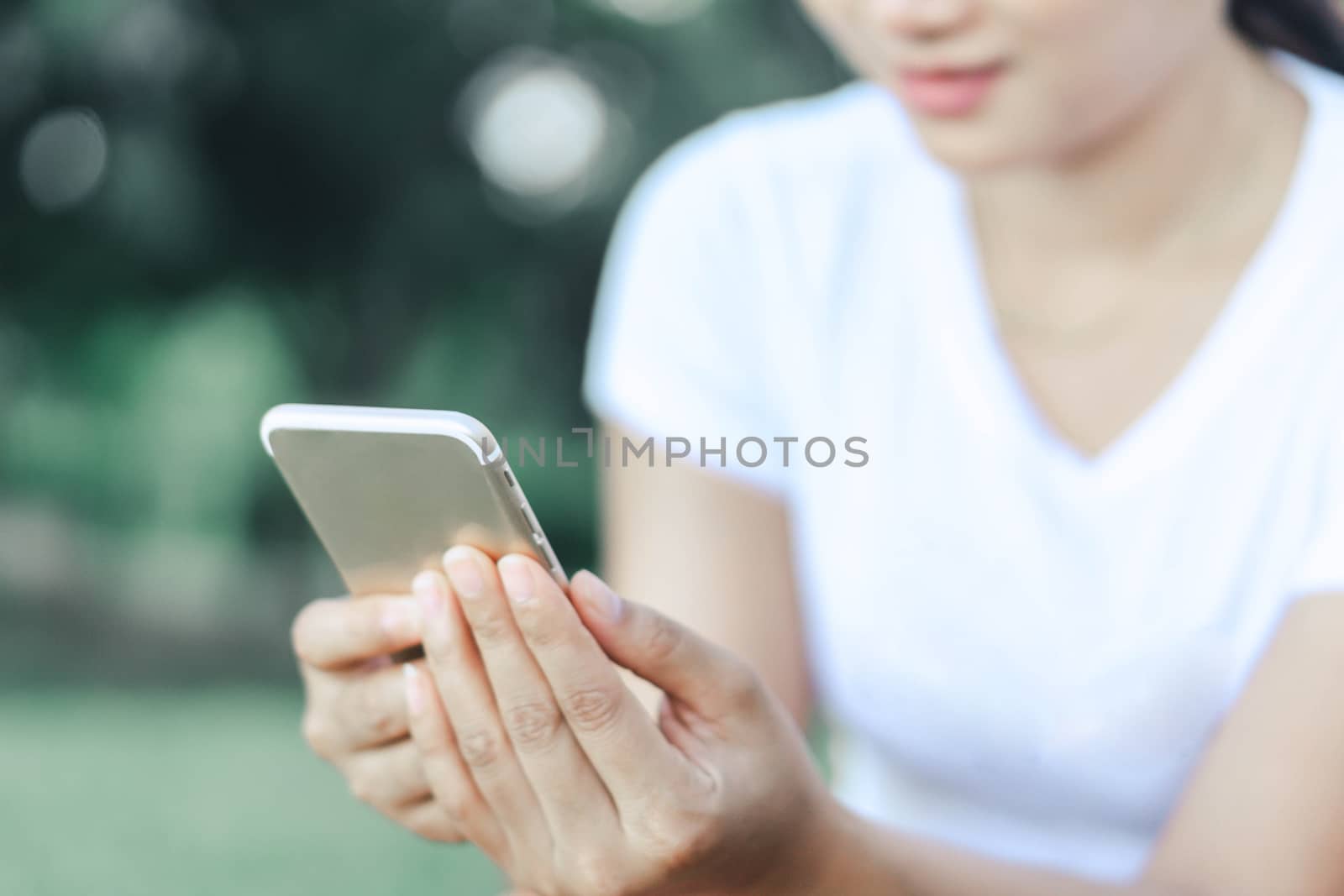 Closeup woman hand playing smartphone mobile with relaxing feelling, selective focus