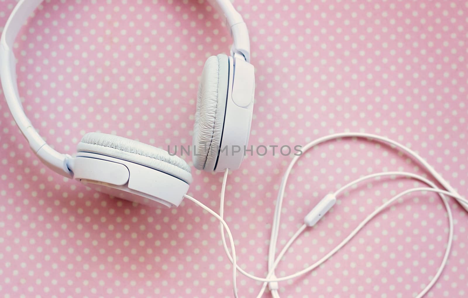 White headphones on pink background