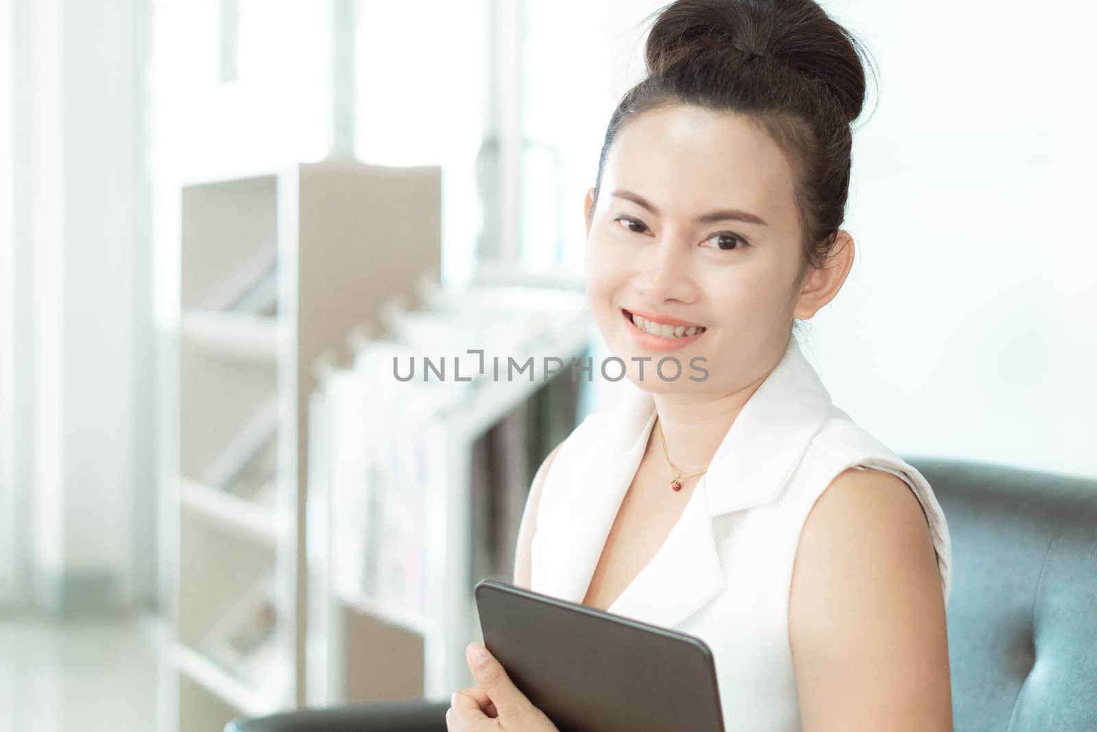 Business woman holding digital tablet with smiling and looking a by pt.pongsak@gmail.com