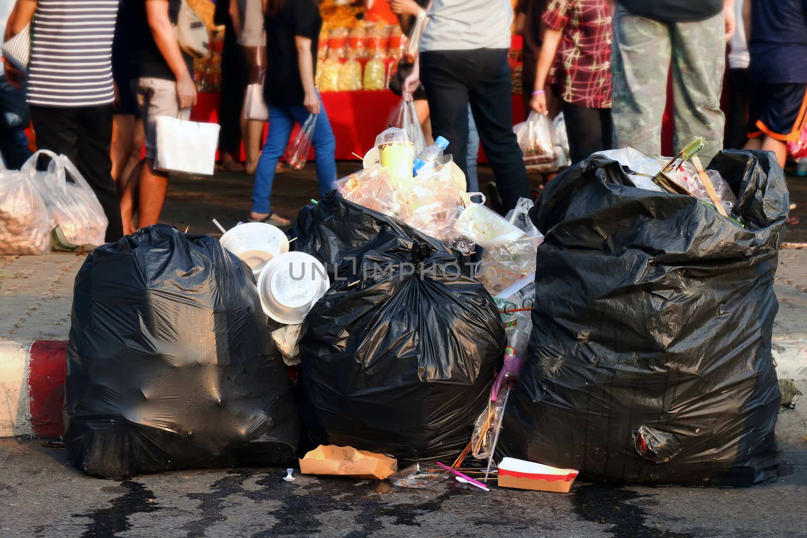 Pile of Garbage plastic black and trash bag waste many on the footpath, pollution trash, Plastic Waste and Bag Foam tray Garbage many on floor, Waste plastic are background people walking at the road by cgdeaw