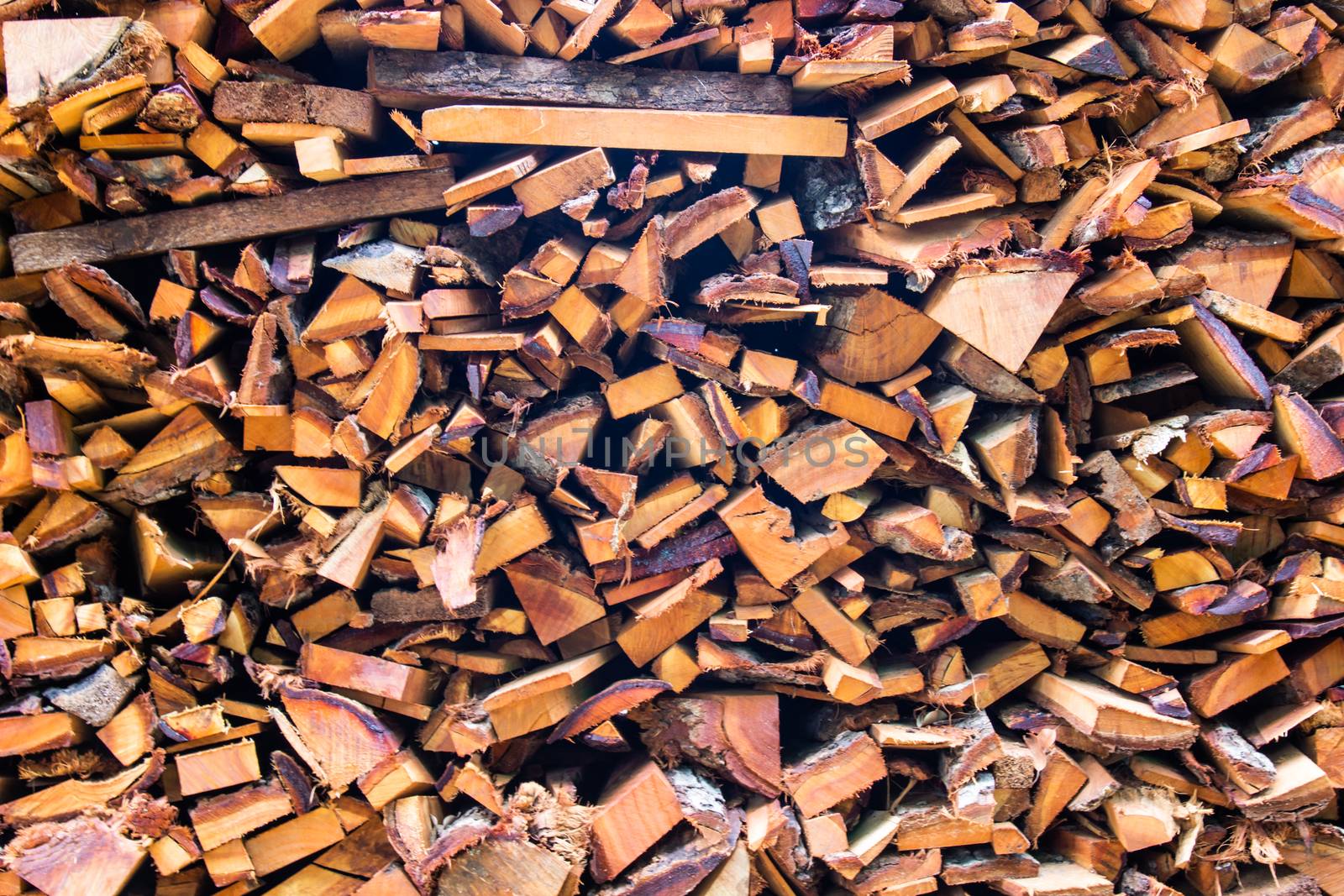 Firewood wooden logs big chopped trunks stacked pile dry for used fireplace in winter.