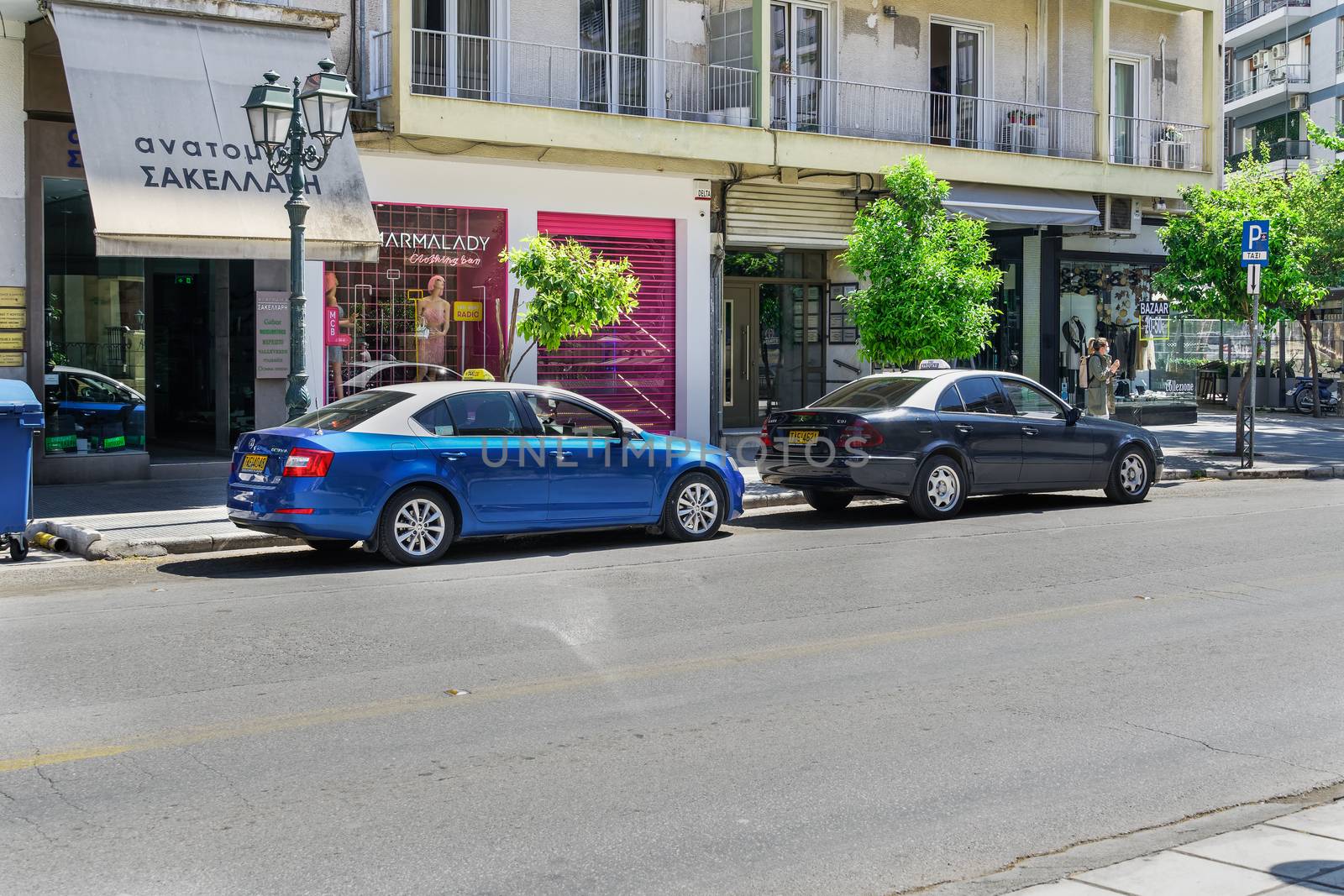 Blue and white taxis with drivers, parked at taxi stop, in Mitropoleos street.