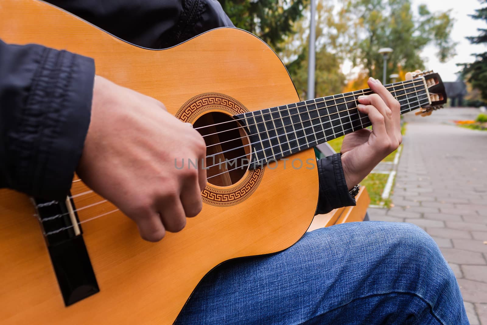 Musician playing guitar in public park