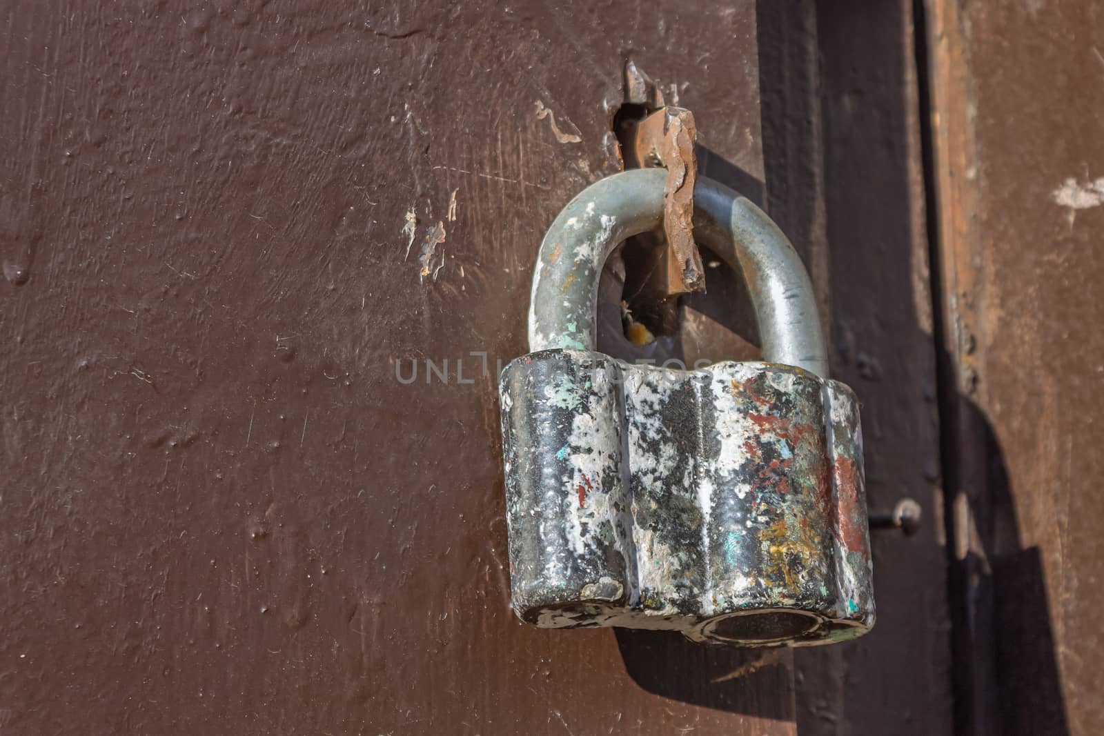 An old but reliable padlock locks the iron gates of the hangar. The lock keeps the doors locked