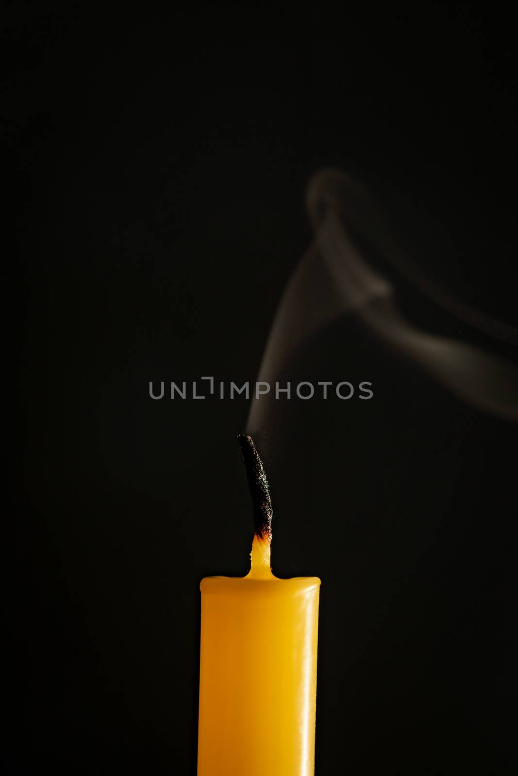 Close-up of yellow candles that are extinguished and smoke in a  by ToonPhotoClub