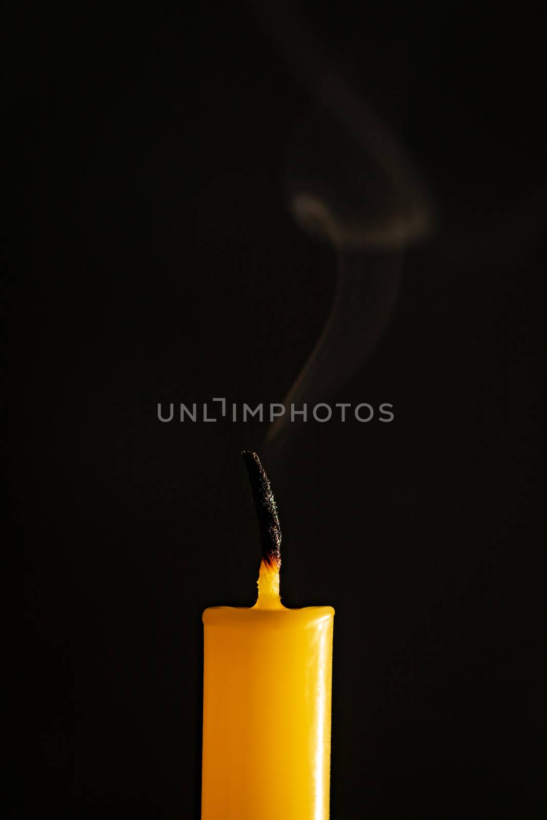 Close-up of yellow candles that are extinguished and smoke in a  by ToonPhotoClub