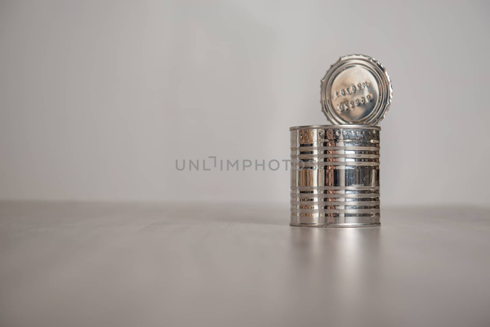 open tin can on a light gray background by marynkin