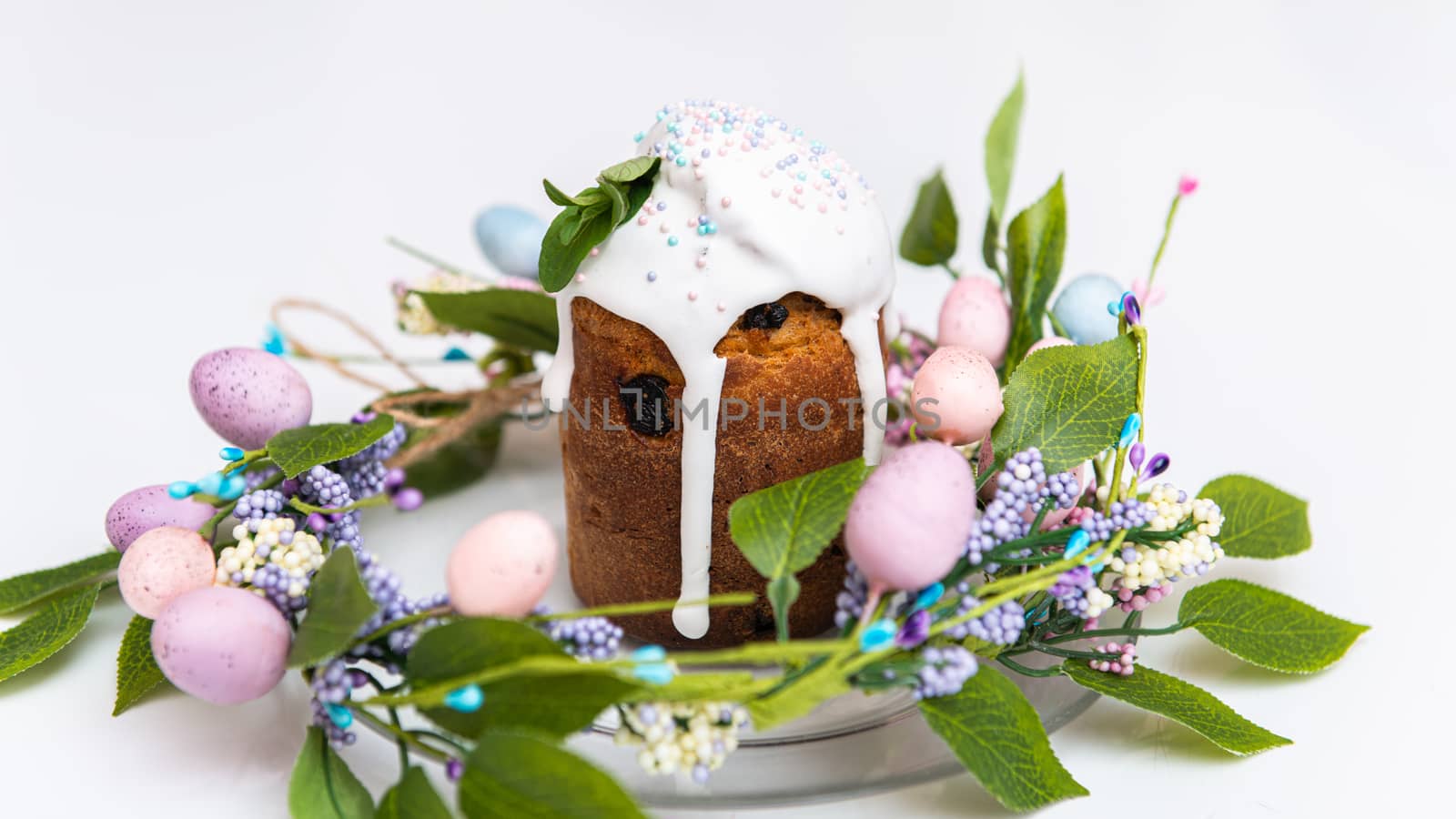 Easter cake in the center of a wreath of spring flowers on a white background with copy space by marynkin