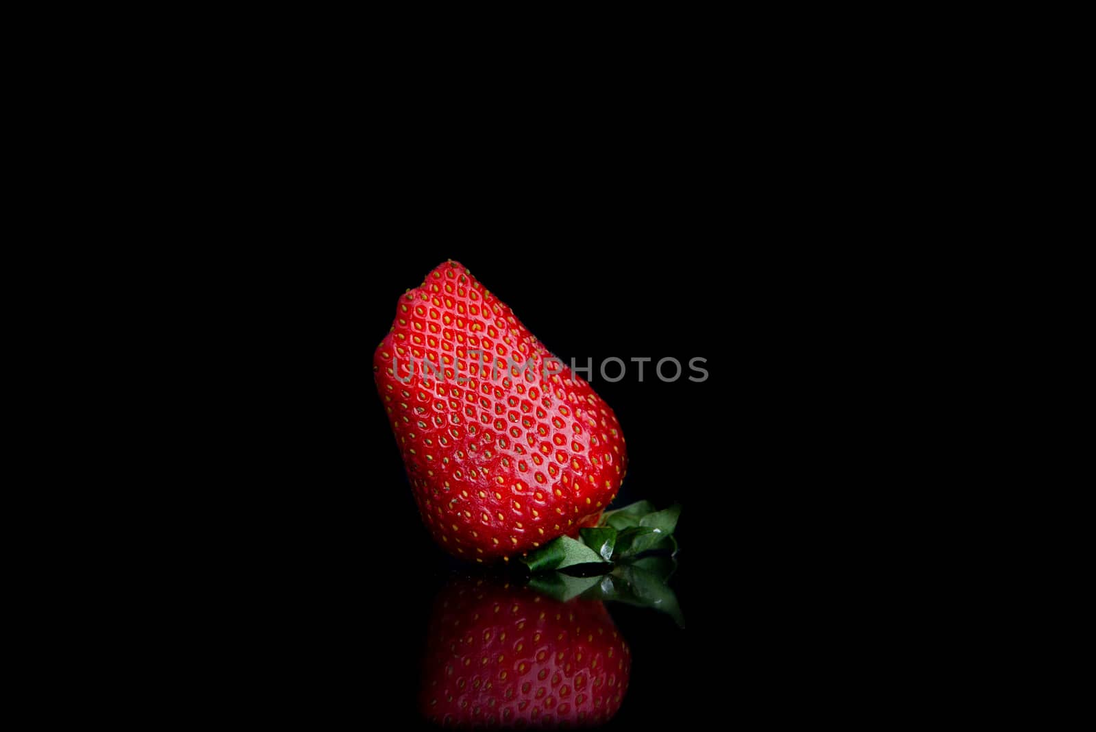 fresh strawberries on a black background with reflection