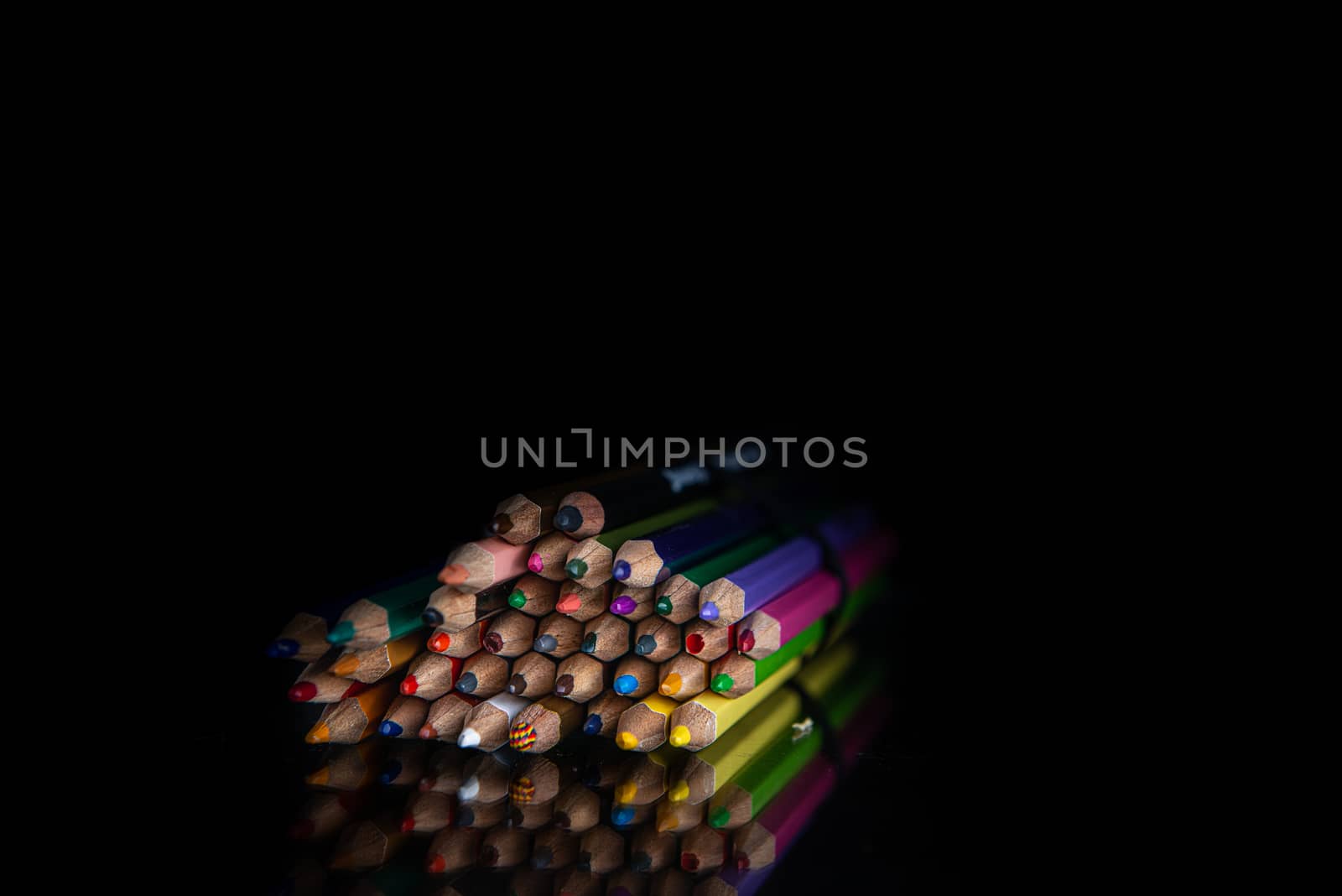 stack of colored pencils on a black background with copy space by marynkin
