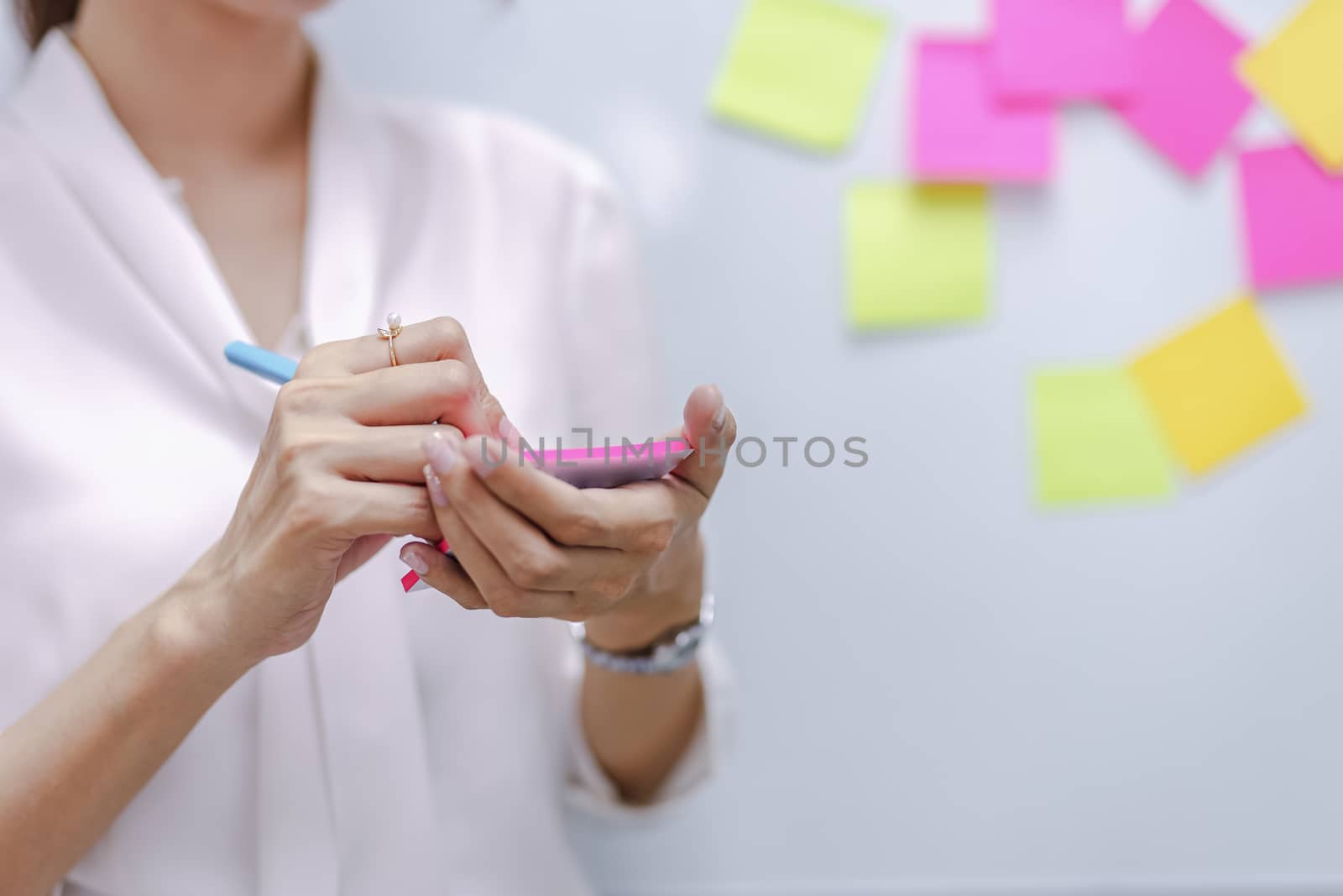 A business person is holding a pen and notes on the assignment