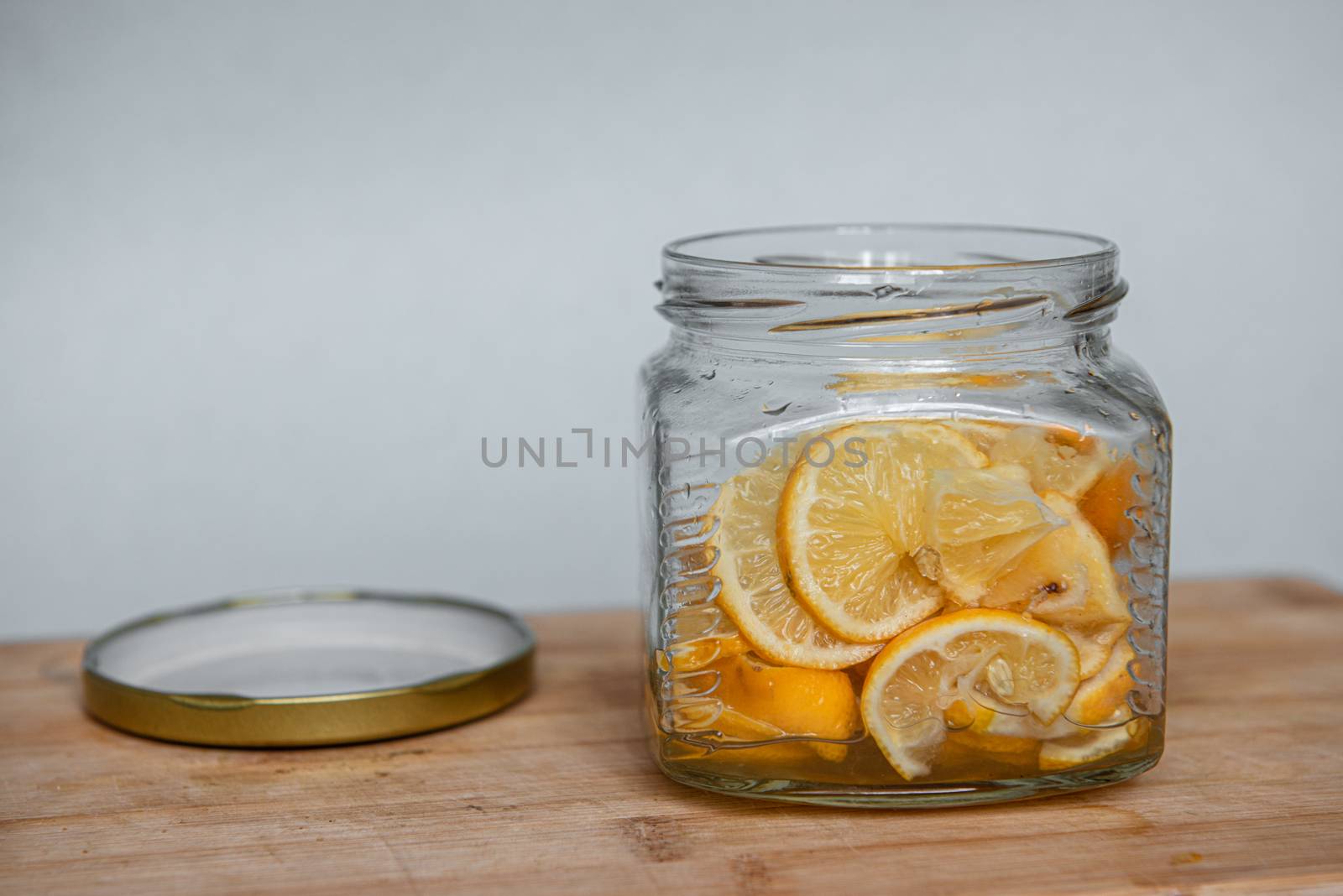 Sweet dessert of thinly sliced lemon with sugar in a glass jar