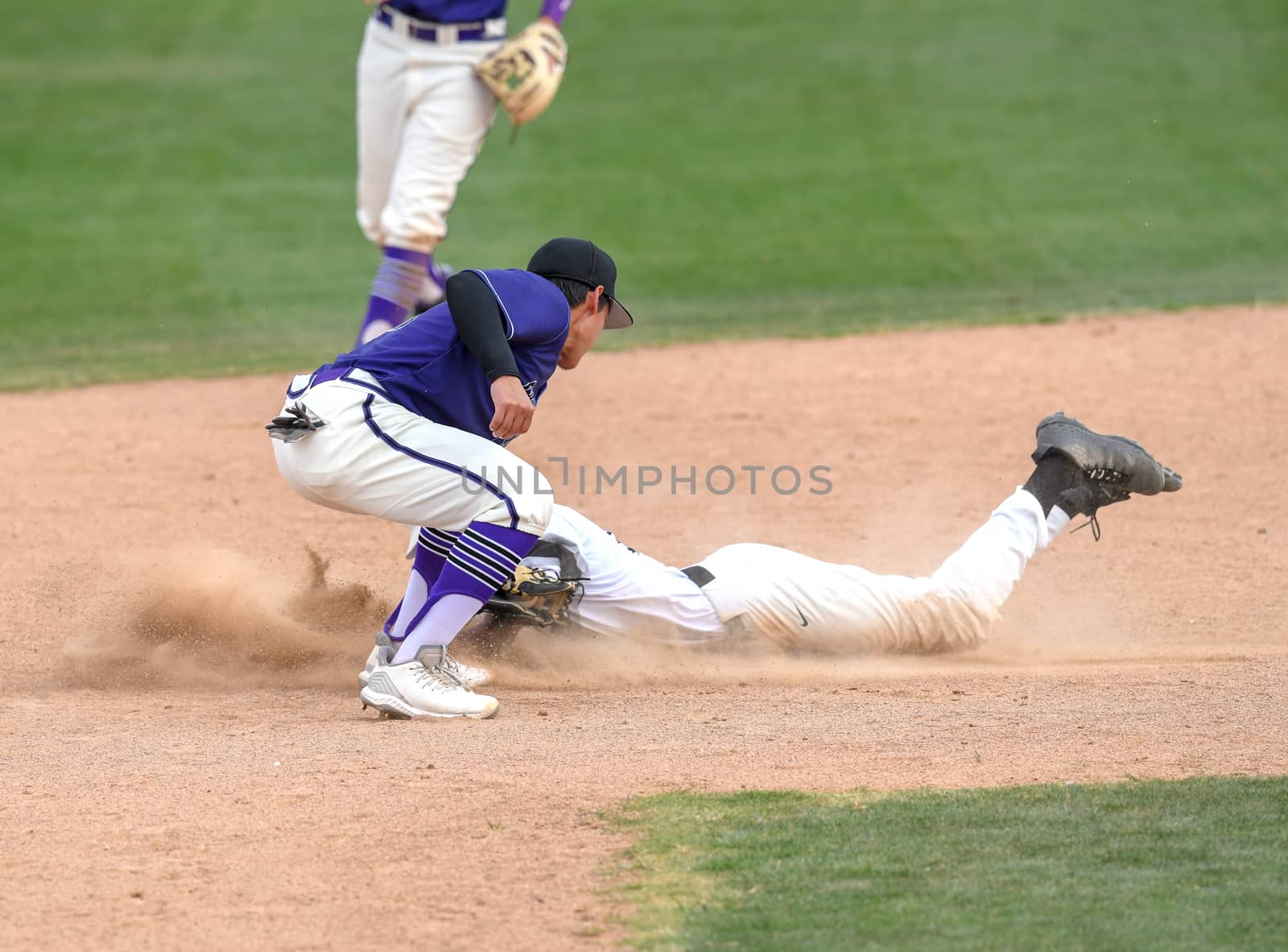 Action photo of high school baseball players making amazing plays during a baseball game