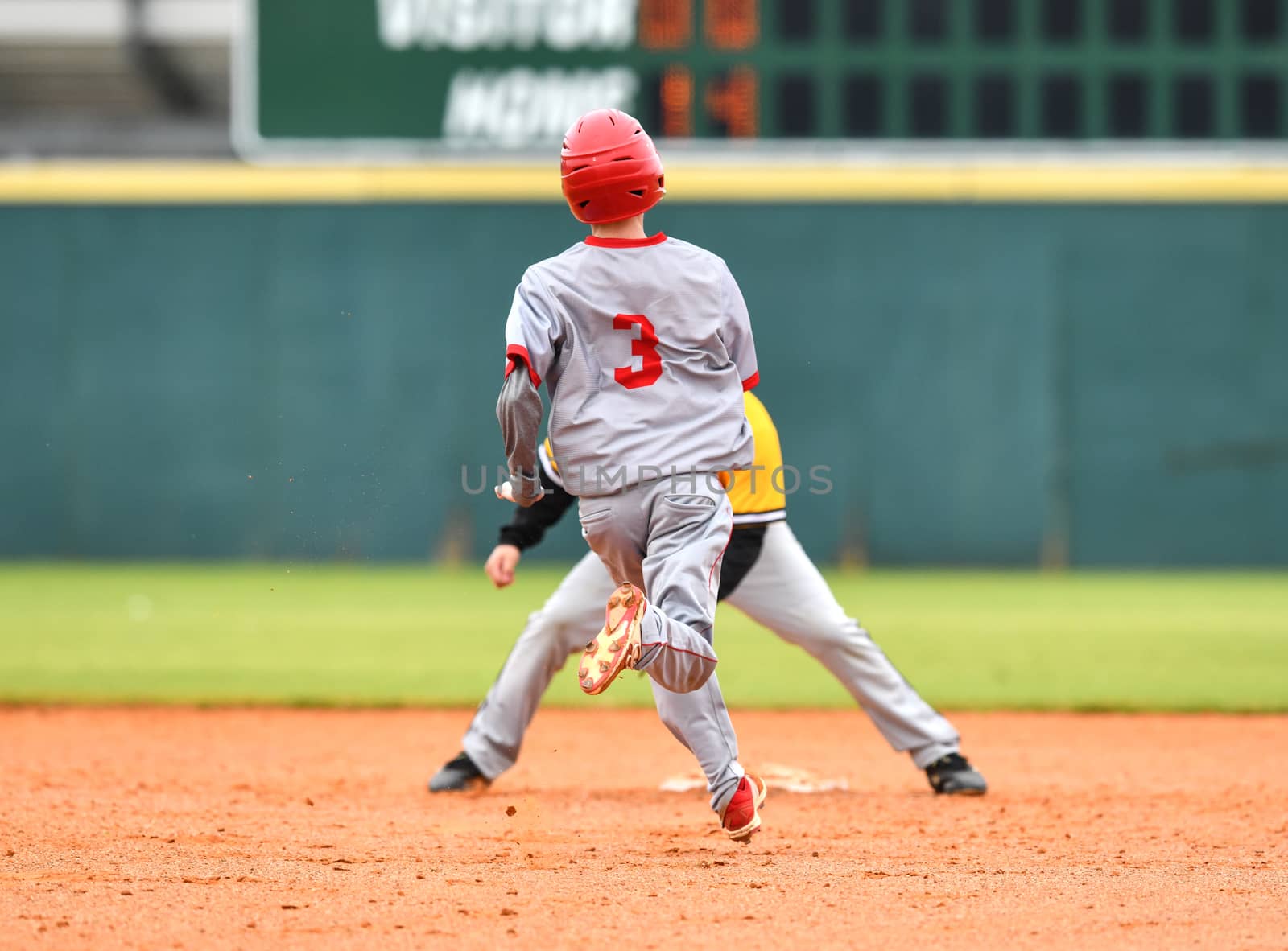 Action photo of high school baseball players making amazing plays during a baseball game