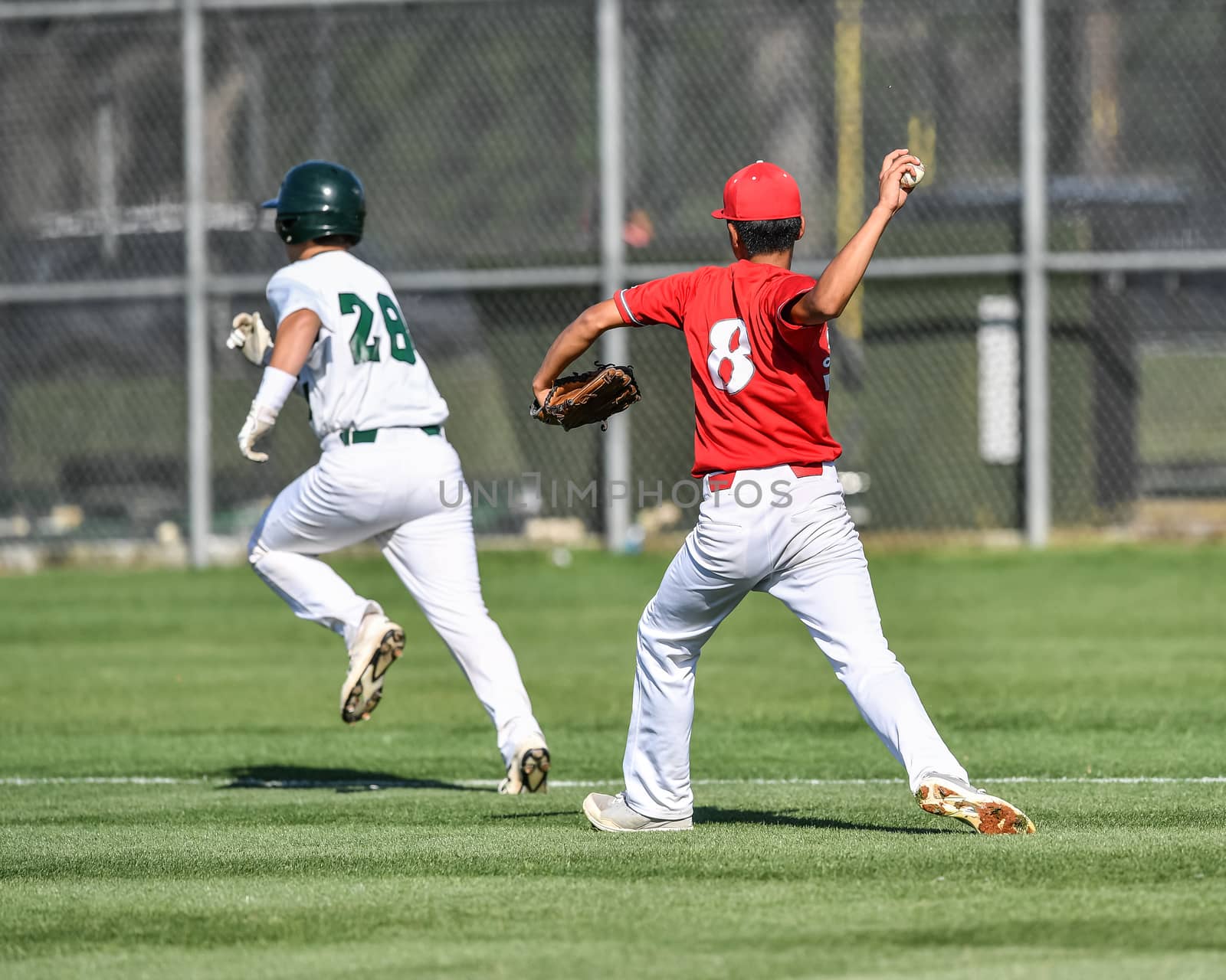 Action photo of high school baseball players making amazing plays during a baseball game