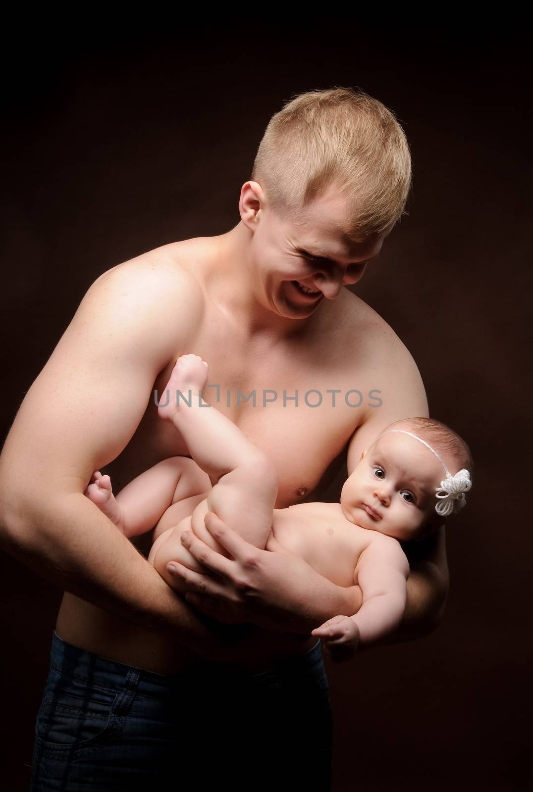 Male holding nice infant baby girl. Daughter on father's arms. Human growth and development. New generation. Cheerful man and his baby. New life concept