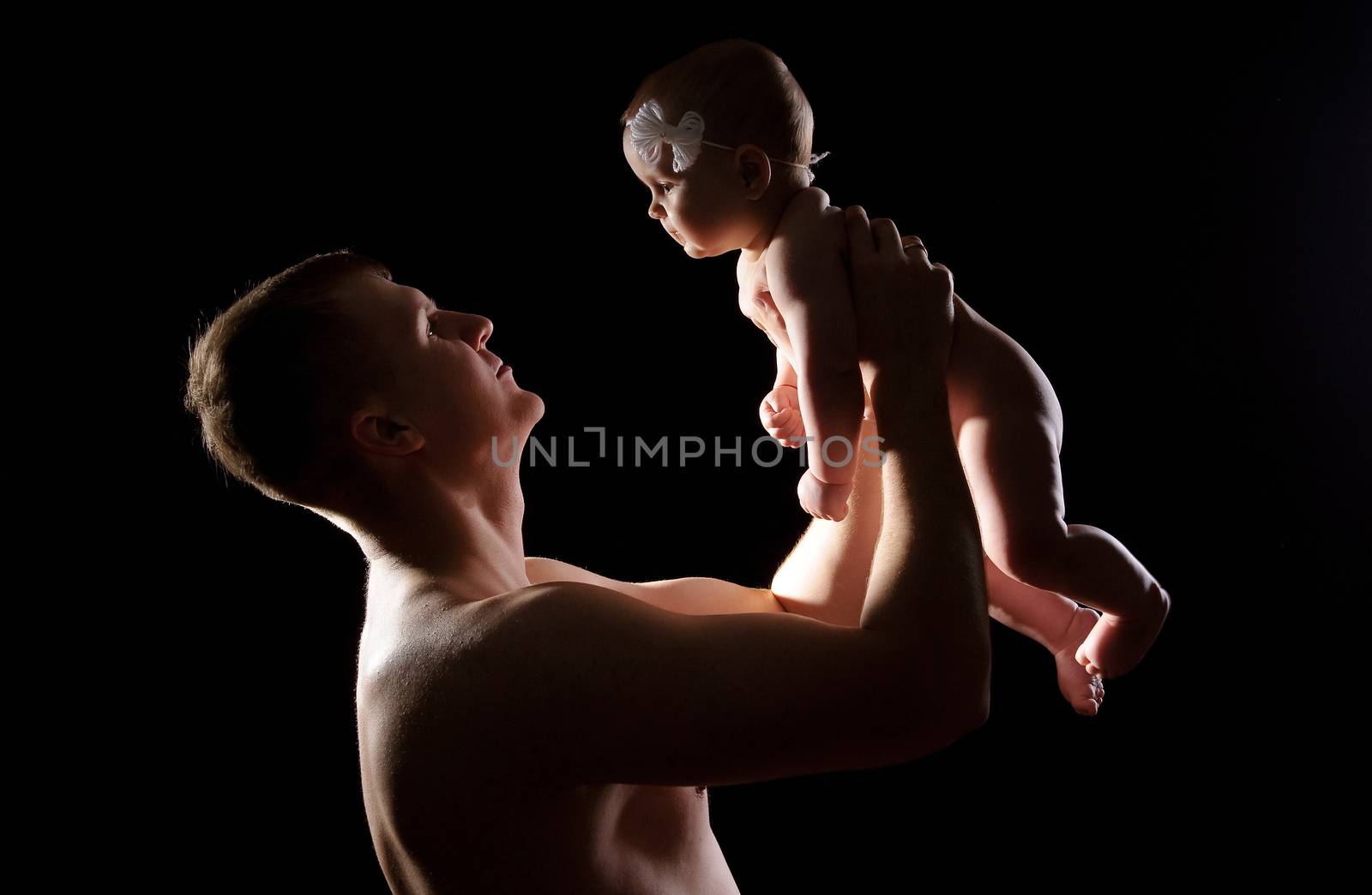 Male holding nice infant baby girl. Daughter on father's arms. Human growth and development. New generation. Cheerful man and his baby. New life concept. Silhouette