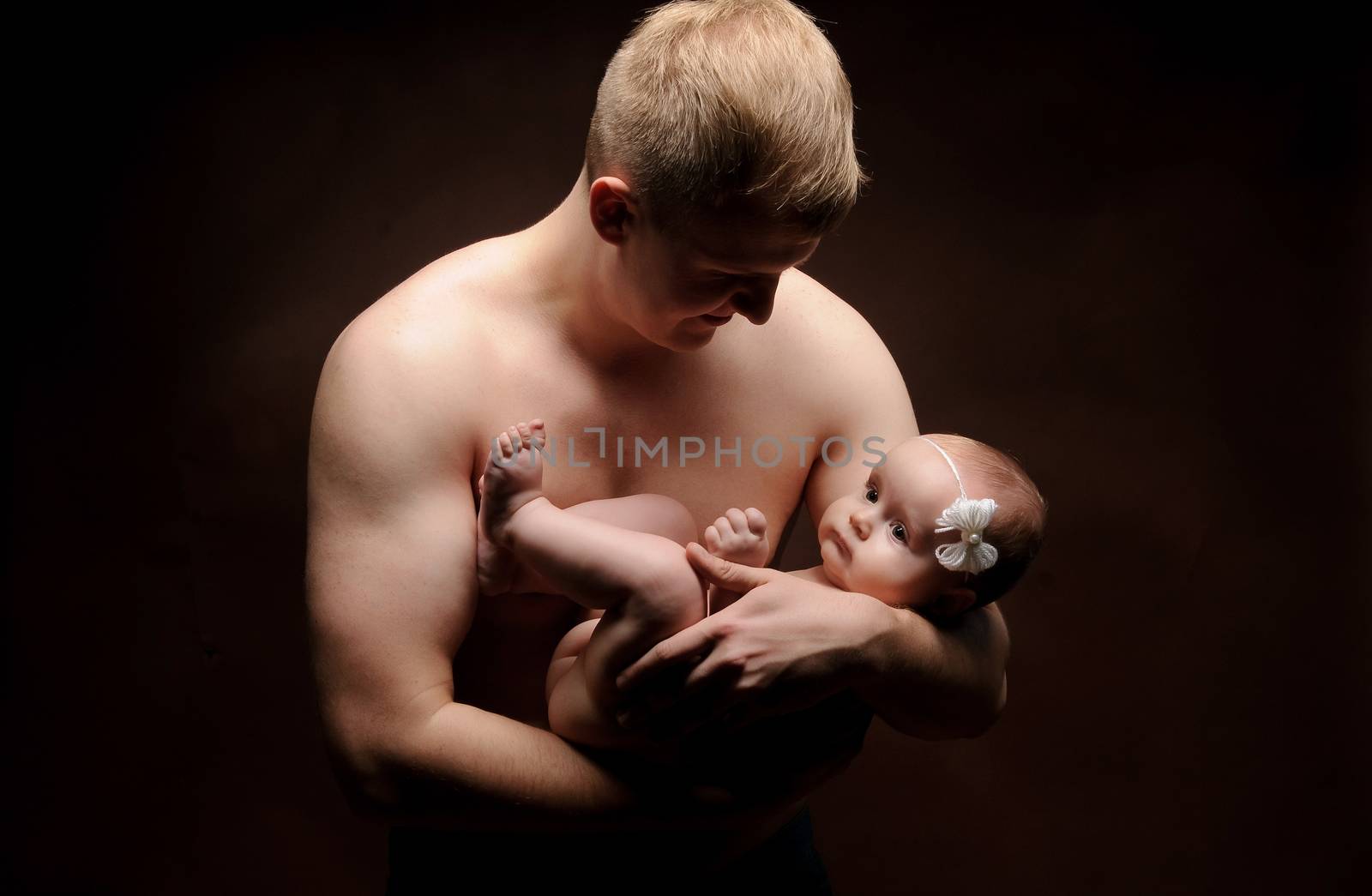 Male holding nice infant baby girl. Daughter on father's arms. Human growth and development. New generation. Cheerful man and his baby. New life concept