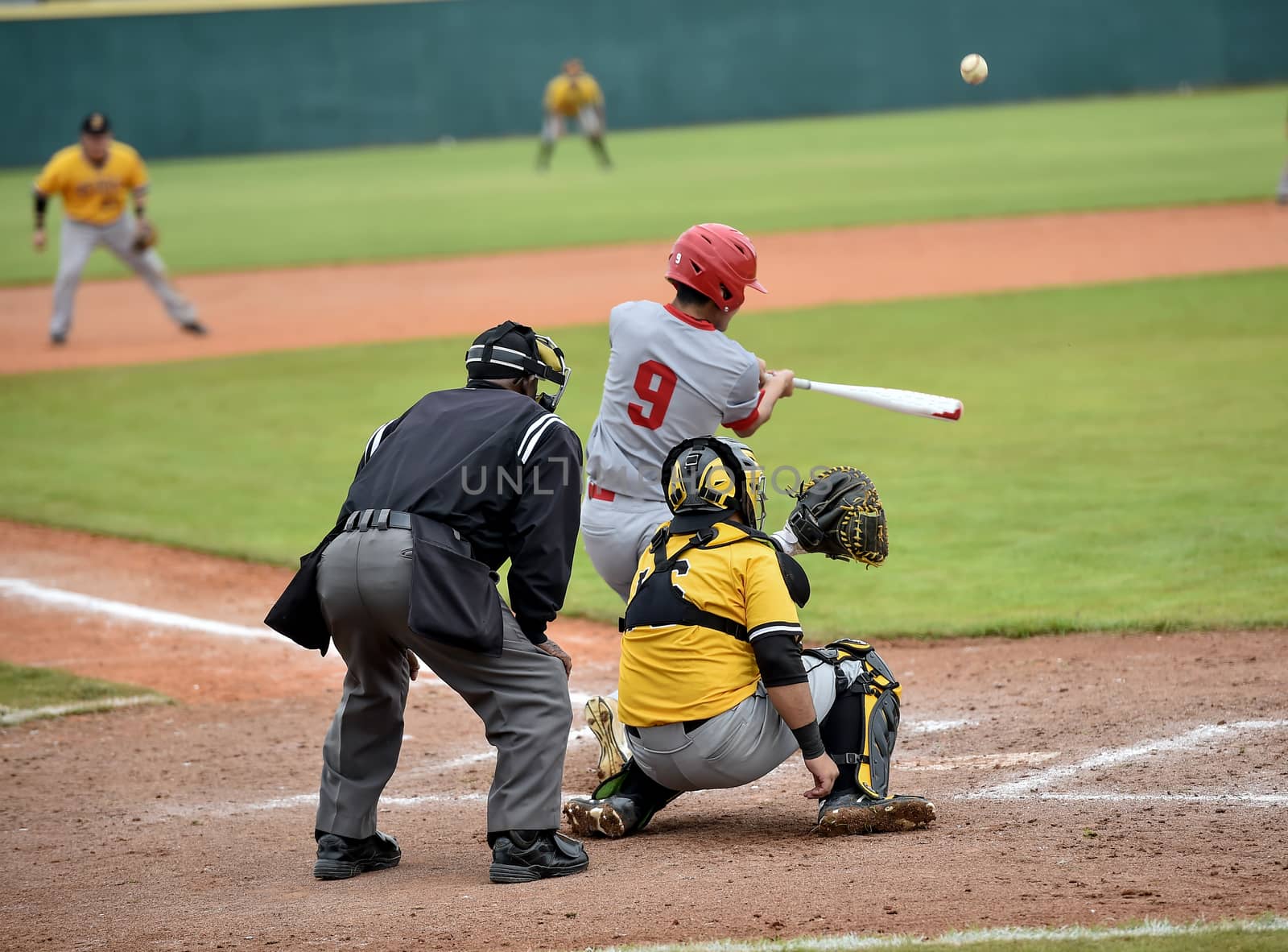 Action photo of high school baseball players making amazing plays during a baseball game