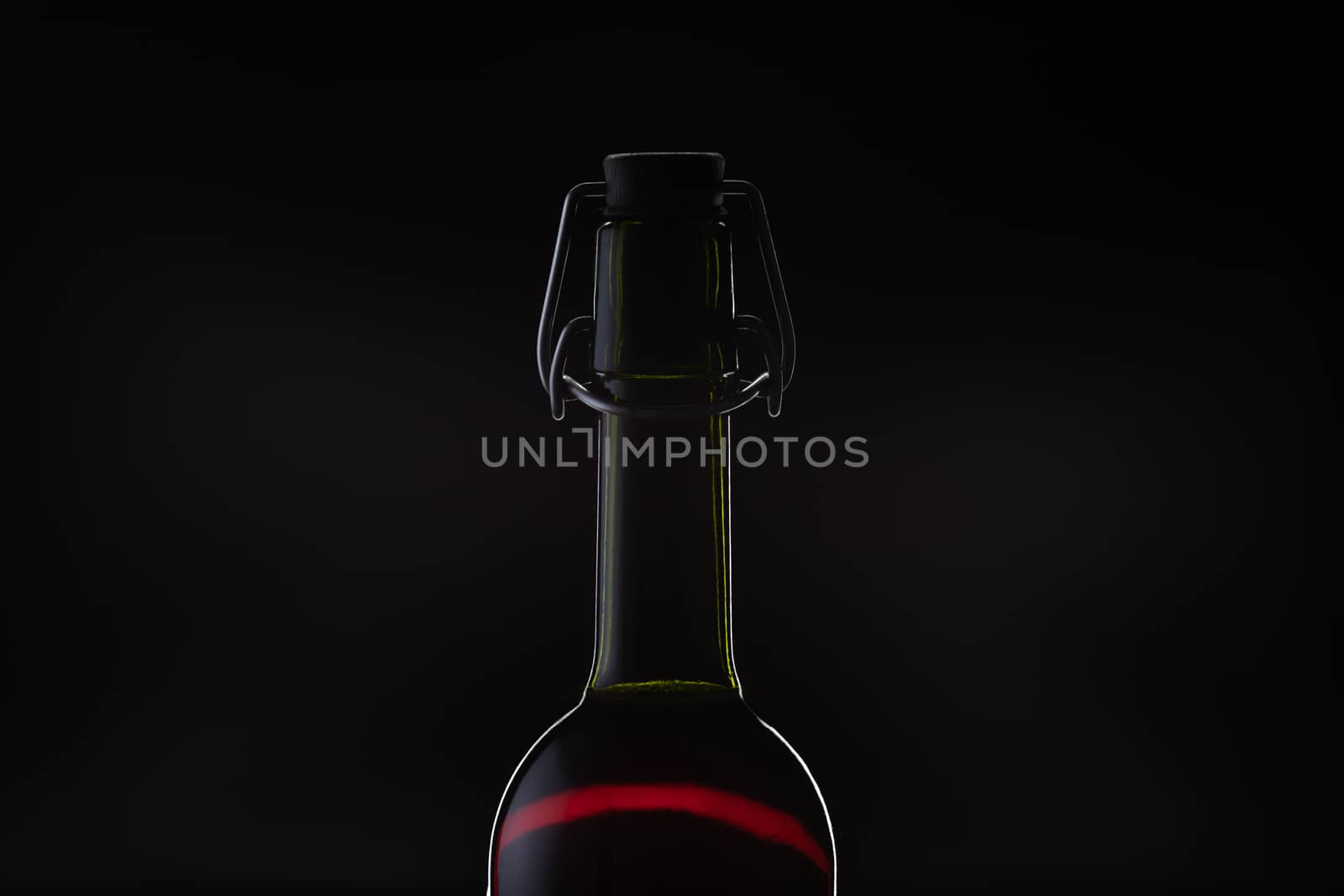 Rose wine. Red wine in bottle and metal opener on cork. Dark background. Silhouette