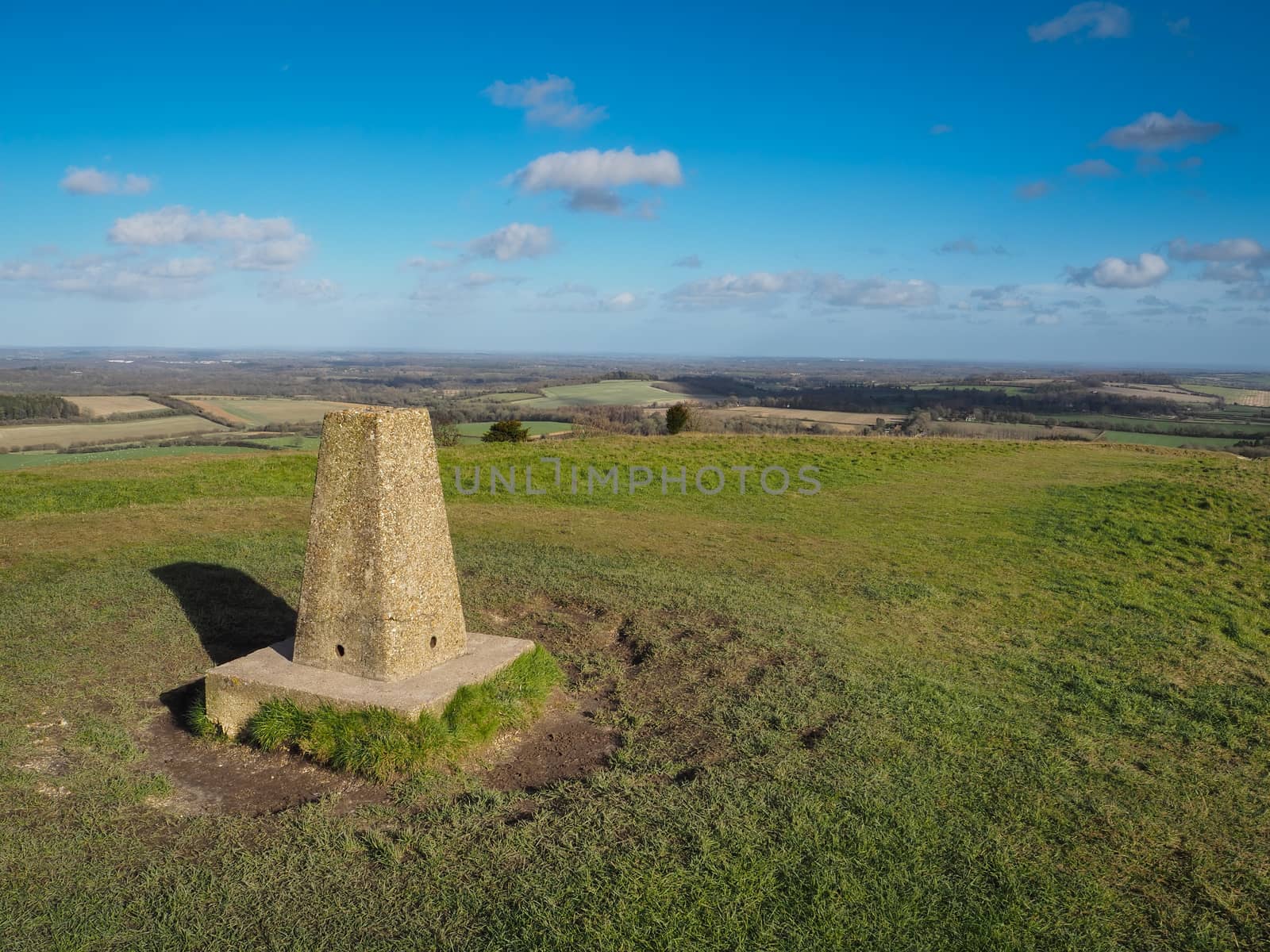 Triangulation point at the top of Beacon Hill, Burghclere, near Newbury looking east across Waterhsip Down and home counties countryside with clouds set against a blue sky, Berkshire, UK